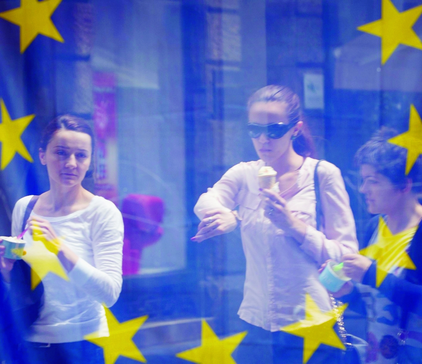 A street scene is reflected in the window of a library with an EU flag on display  in downtown  Zagreb, Croatia, Sunday, June 30, 2013. Croatia is to join the European Union on July 1, 2013. (AP Photo/Darko Bandic) Croatia Entering EU