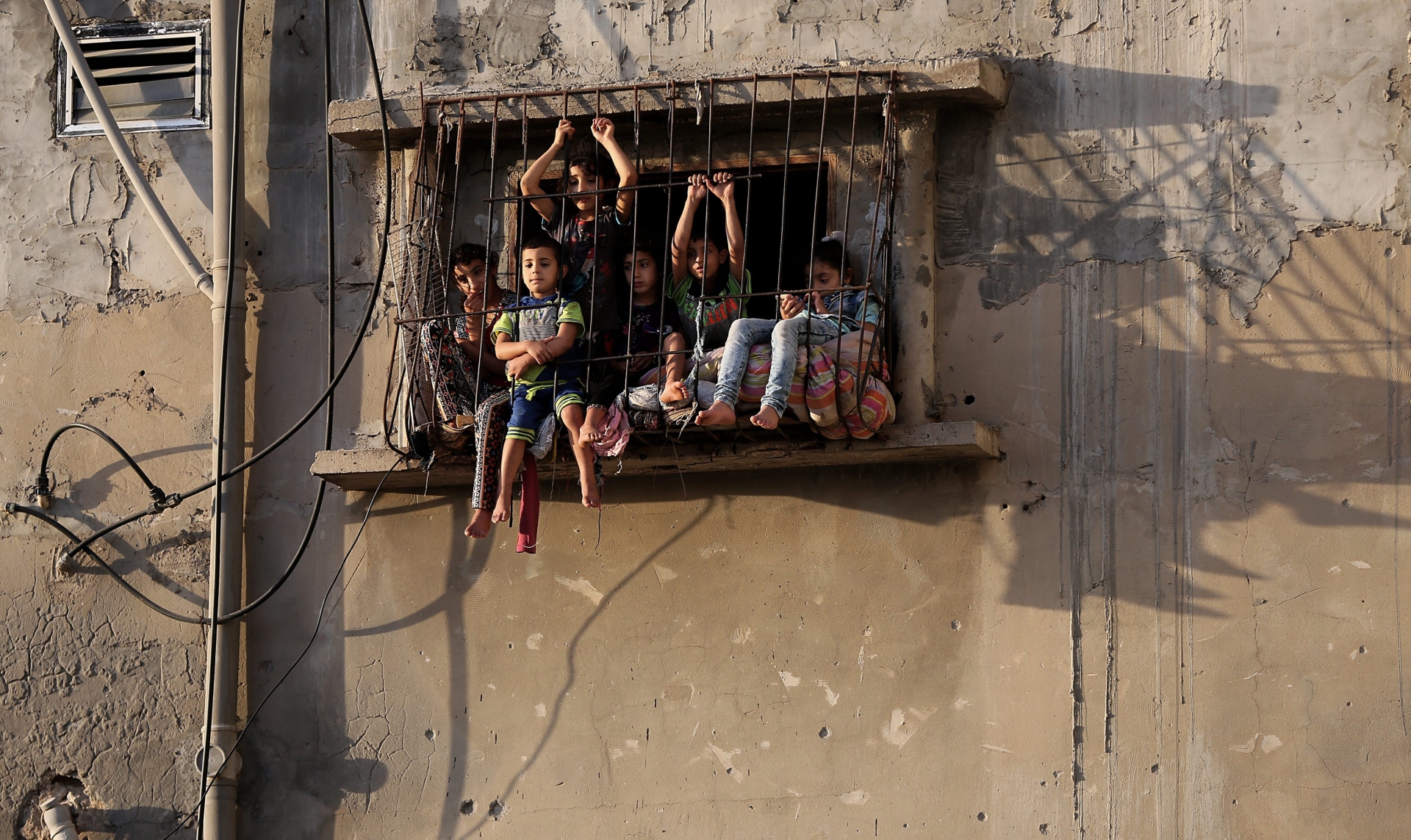 epa05291303 A picture made available on 06 May 2016 shows Palestinian children sitting at the window of their family house in the east of Al Shejaeiya neighborhood, east of Gaza City near the border between the Gaza strip and Israel, 05 May 2016. Israeli air strikes hit four Hamas sites in the east of Gaza City overnight. According to media reports, the airstrikes were conducted as retaliation for mortar attacks on Israeli Defense Force personnel along the border region.  EPA/MOHAMMED SABER MIDEAST ISRAEL PALESTINIANS ISRAELI STRIKES