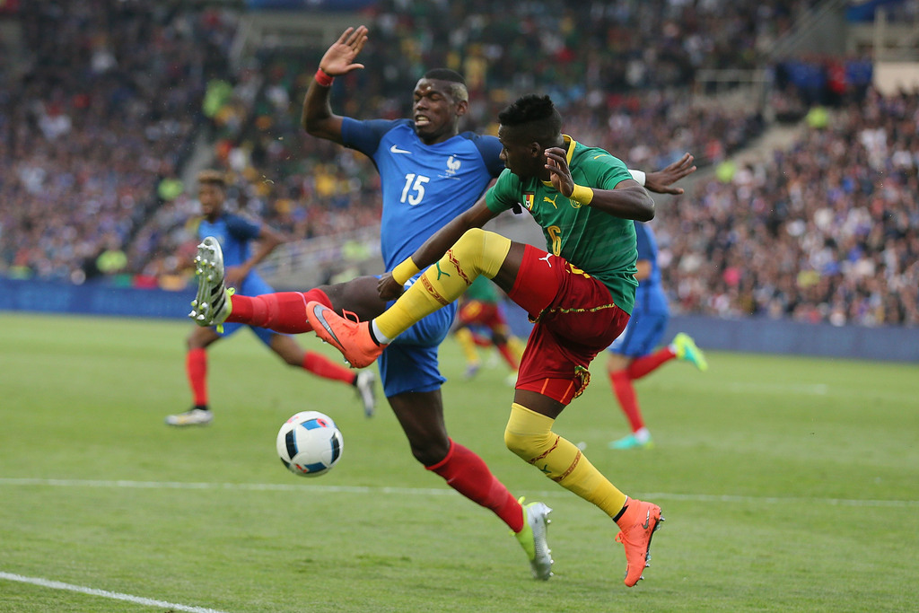 Le Camerounais Ambroise Oyongo Bitolo,à droite, à la lutte avec le Français Paul Pogba. L'équipe tricolore a remporté la rencontre sur le fil.