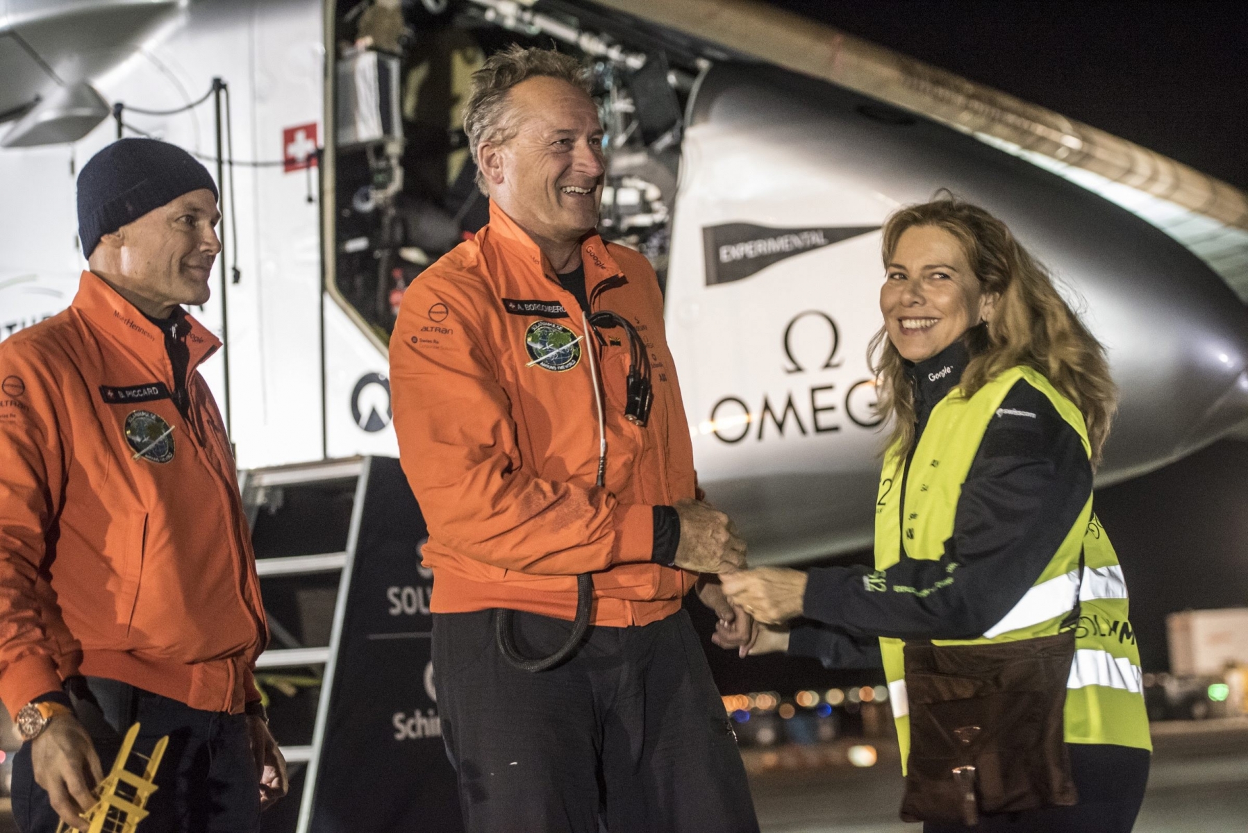 epa05322538 A handout picture made available by Global Newsroom on 22 May 2016 shows Swiss adventurer Andre Borschberg (C) being welcomed by his wife Yasemin (R) and alternate pilot Bertrand Piccard (L) after Solar Impulse 2 (Si2) landed at Dayton International Airport, Ohio, USA, 21 May 2016. The solar-powered aircraft landed at Dayton International Airport, Ohio, on 21 May at 9:56pm local time (UTC-4) after taking off from Tulsa International Airport, Oklahoma, and covering about 1,113 km.  EPA/GLOBAL NEWSROOM / SI2 / HANDOUT  HANDOUT EDITORIAL USE ONLY/NO SALES USA SOLAR IMPULSE 2