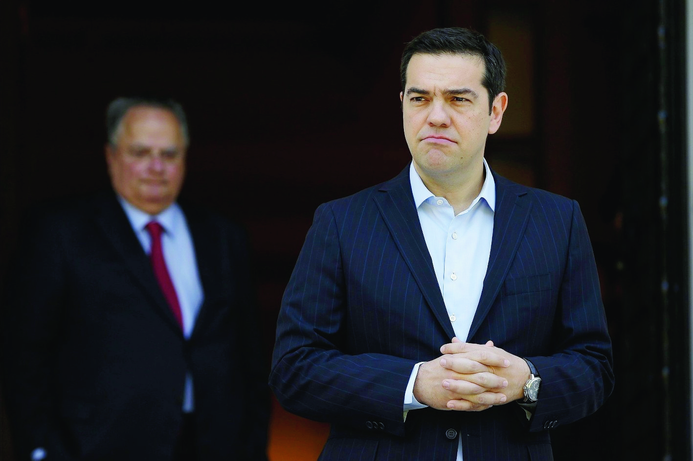 Greece's Prime Minister Alexis Tsirpas, right, waits for the arrival of the Cypriot President Nicos Anastasiades at the Maximos Mansion in Athens, Wednesday, May 25, 2016. Greece has won an essential batch of bailout funds from international creditors following agreement among the 19 eurozone finance ministers and can start looking forward to debt relief in the future. (AP Photo/Thanassis Stavrakis) Greece Bailout