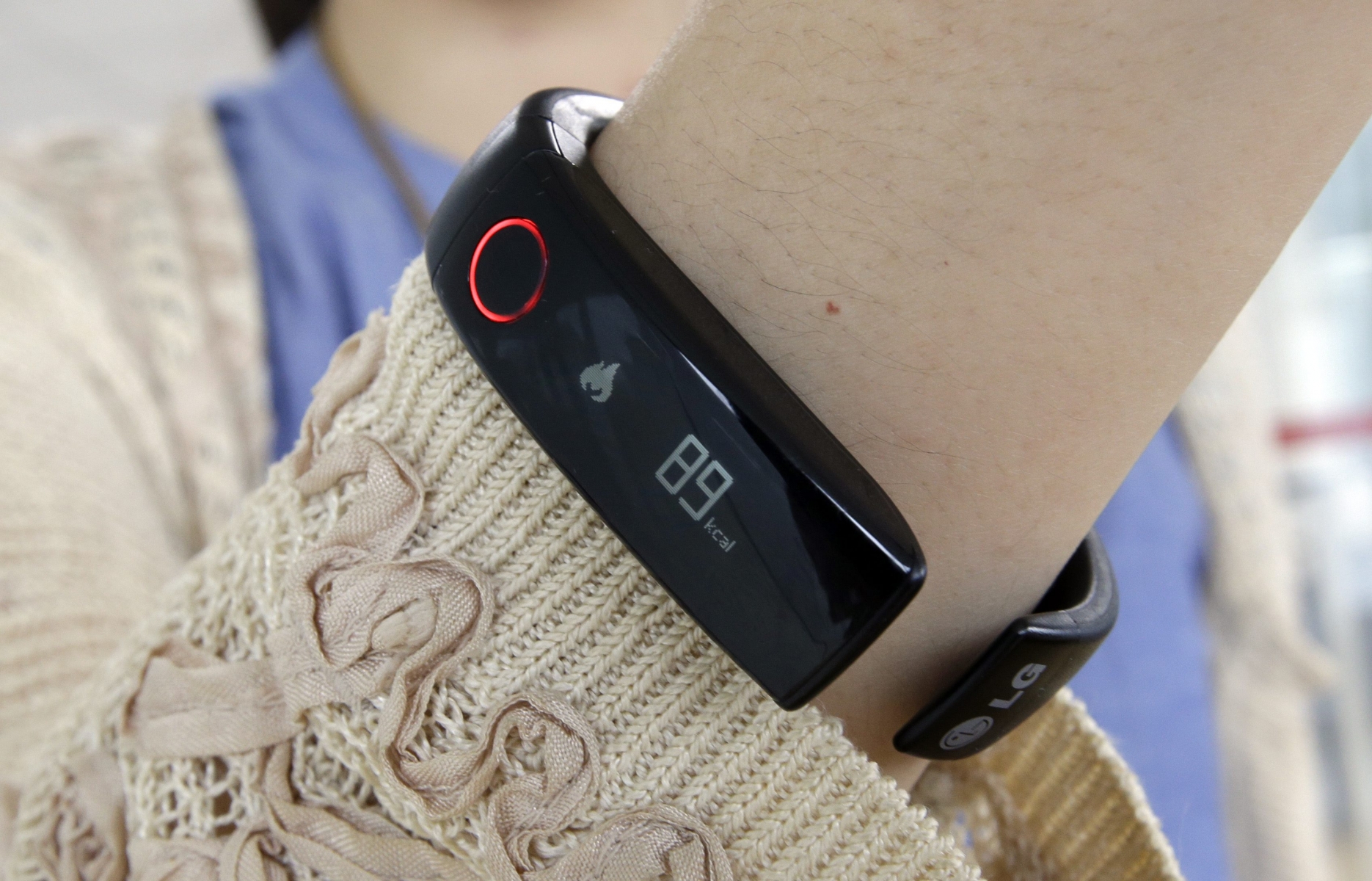 In this June 5, 2014 photo, a reporter shows LGís Lifeband Touch for photographs in Seoul, South Korea. LG Electronics Inc. has entered the fledging market for wearable gadgets with a wristband that tracks workouts and calories burned. (AP Photo/Lee Jin-man)