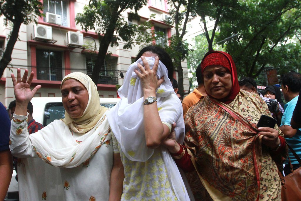 Des personnes venant identifier des corps après la prise d'otage sanglante d'un restaurant à Dacca. 