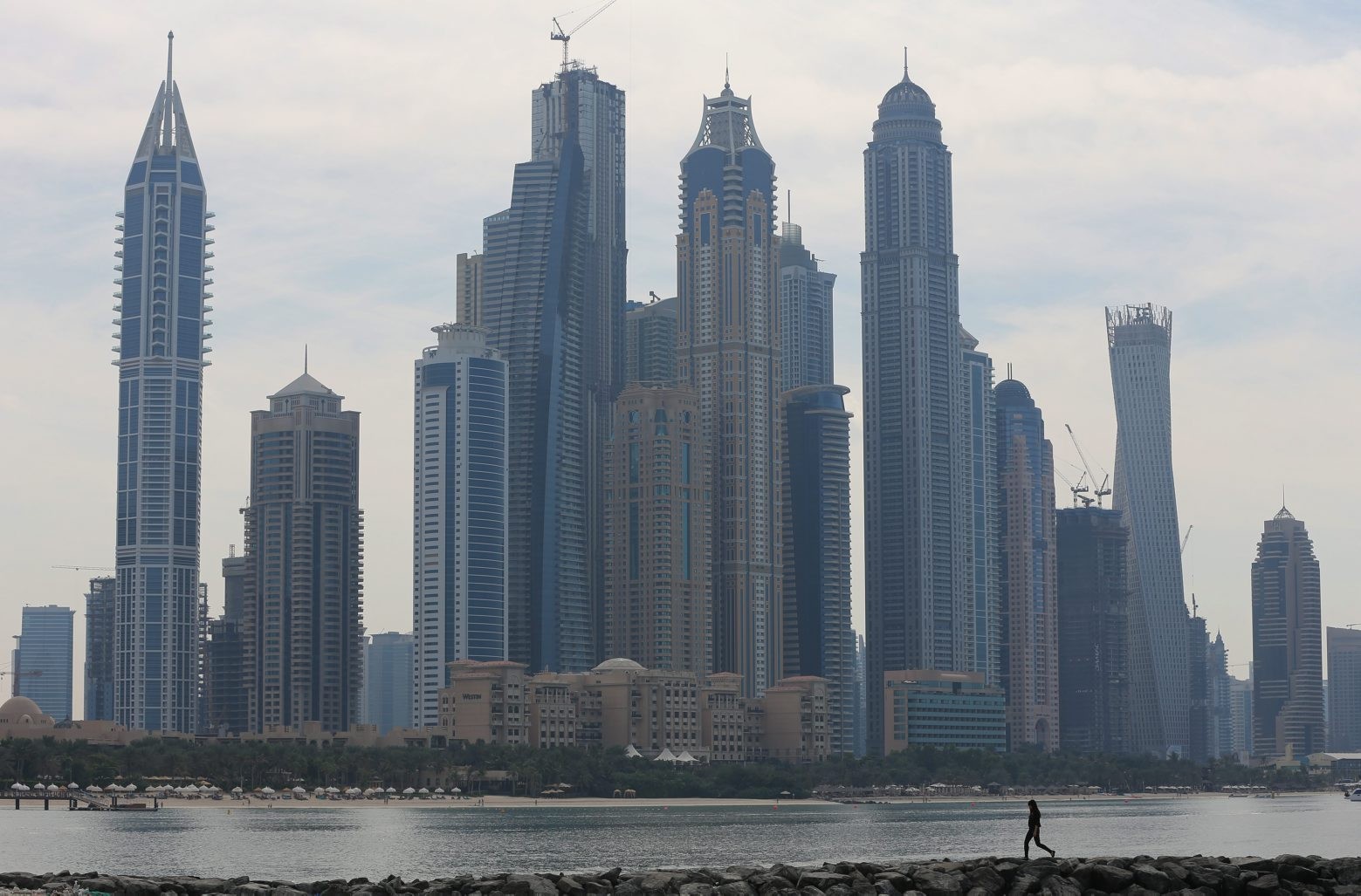 (Embargoed until after midnight GMT) A woman walks past luxury towers in the Marina district of Dubai, United Arab Emirates, Monday, Nov.17, 2014. The United Arab Emirates has quietly mounted ìan unprecedented clampdown on dissentî since 2011, with more than 100 political activists jailed or prosecuted for calling for political reforms, leading human rights group Amnesty International said in a report released Monday. The UAE, home to Abu Dhabi and Dubai, is ruled by families, like much of the energy-rich Gulf. There are no political parties and foreigners greatly outnumber locals. (AP Photo/Kamran Jebreili) Mideast Emirates Rights