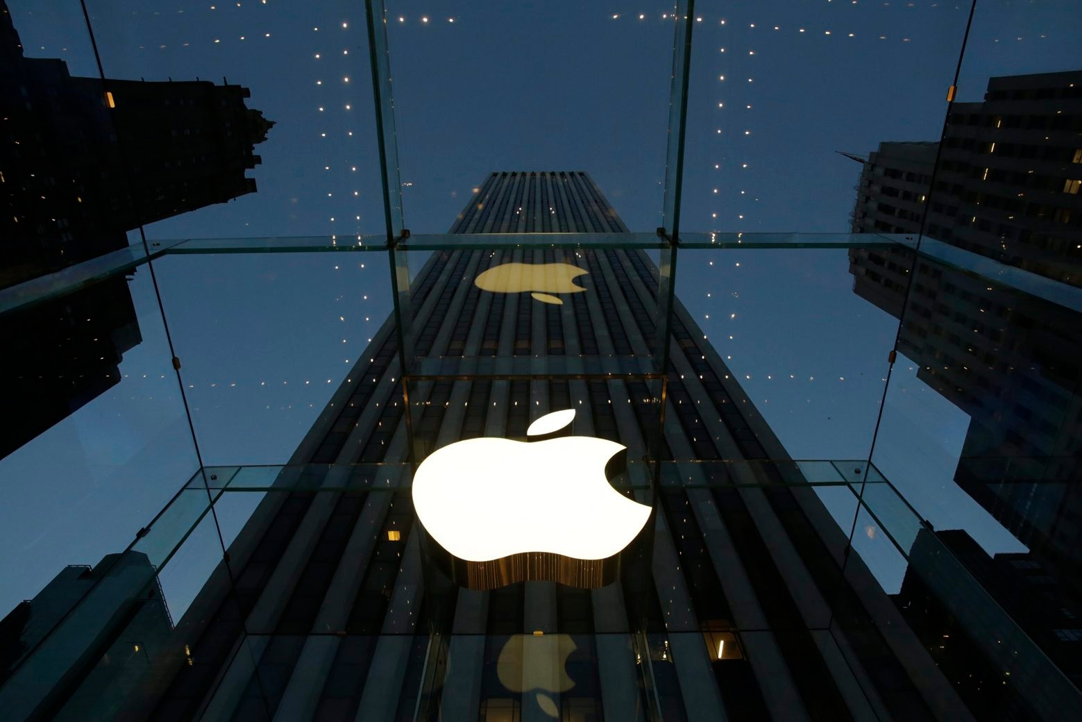 FILE - In this Wednesday, Nov. 20, 2013, file photo, the Apple logo is illuminated in the entrance to the Fifth Avenue Apple store, in New York. Apple Inc. reports quarterly financial results after the market closes Monday, Jan 27, 2014. (AP Photo/Mark Lennihan, File) Earns Apple