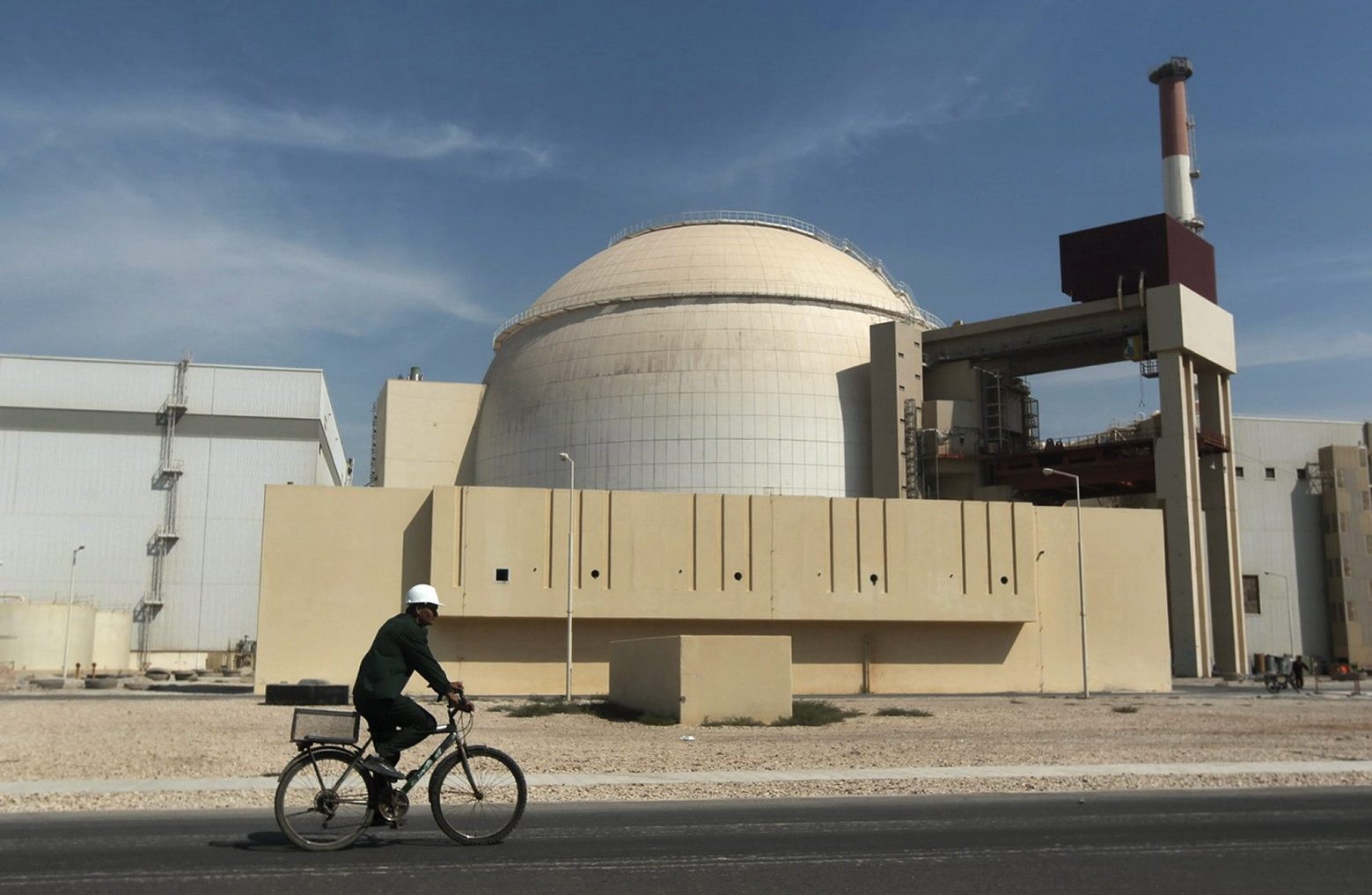 ZUM JAHRESTAG DES ATOMABKOMMENS MIT DEM IRAN, STELLEN WIR IHNEN AM MONTAG 11. JULI 2016 FOLGENDES ARCHIVBILD ZUR VERFUEGUNG. - In this Oct. 26, 2010 file photo, a worker rides a bicycle in front of the reactor building of the Bushehr nuclear power plant, just outside the southern city of Bushehr, Iran. Assassinations, cyber-attacks and possible military strikes: As nuclear negotiations with Iran enter a crucial stage, Tehran is voicing fears that tougher oversight of its activities will increase the risks of an attack on its atomic facilities and the scientists working on them. (AP Photo/Mehr News Agency, Majid Asgaripour, File) IRAN ATOMABKOMMEN JAHRESTAG