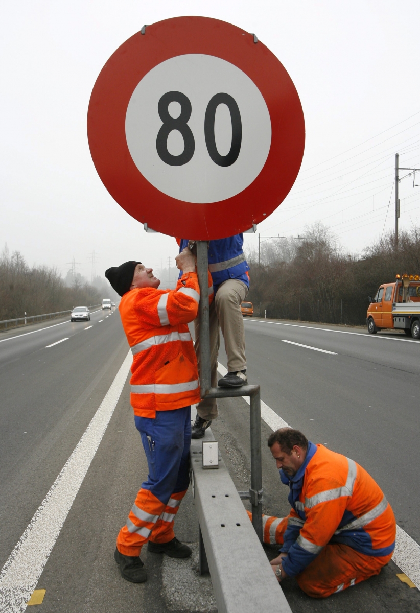 ARCHIVE---Strassenarbeiter stellen eine Tafel mit Geschwindigkeitslimite 80 auf, auf der Autobahn N4 in Zug, am 3. Februar 2006. - Bis zu zehn Prozent weniger Feinstaubbelastung entlang von Autobahnen: Die Temporeduktion Anfang Februar hat Wirkung gezeigt, wie die zustaendigen Regierungsstellen der Kantone Bern und Zuerich am Mittwoch, 12. April 2006 mitteilten. (KEYSTONE/Alessandro Della Bella) SCHWEIZ FEINSTAUB TEMPOREDUKTION