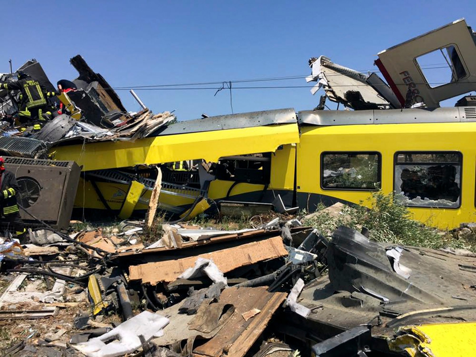 Italian firefighters search among debris at the scene of a train accident after two commuter trains collided head-on near the town of Andria, in the southern region of Puglia, killing several people, Tuesday, July 12, 2016.  (Massimo Mazzilli via AP) APTOPIX Italy Train Crash