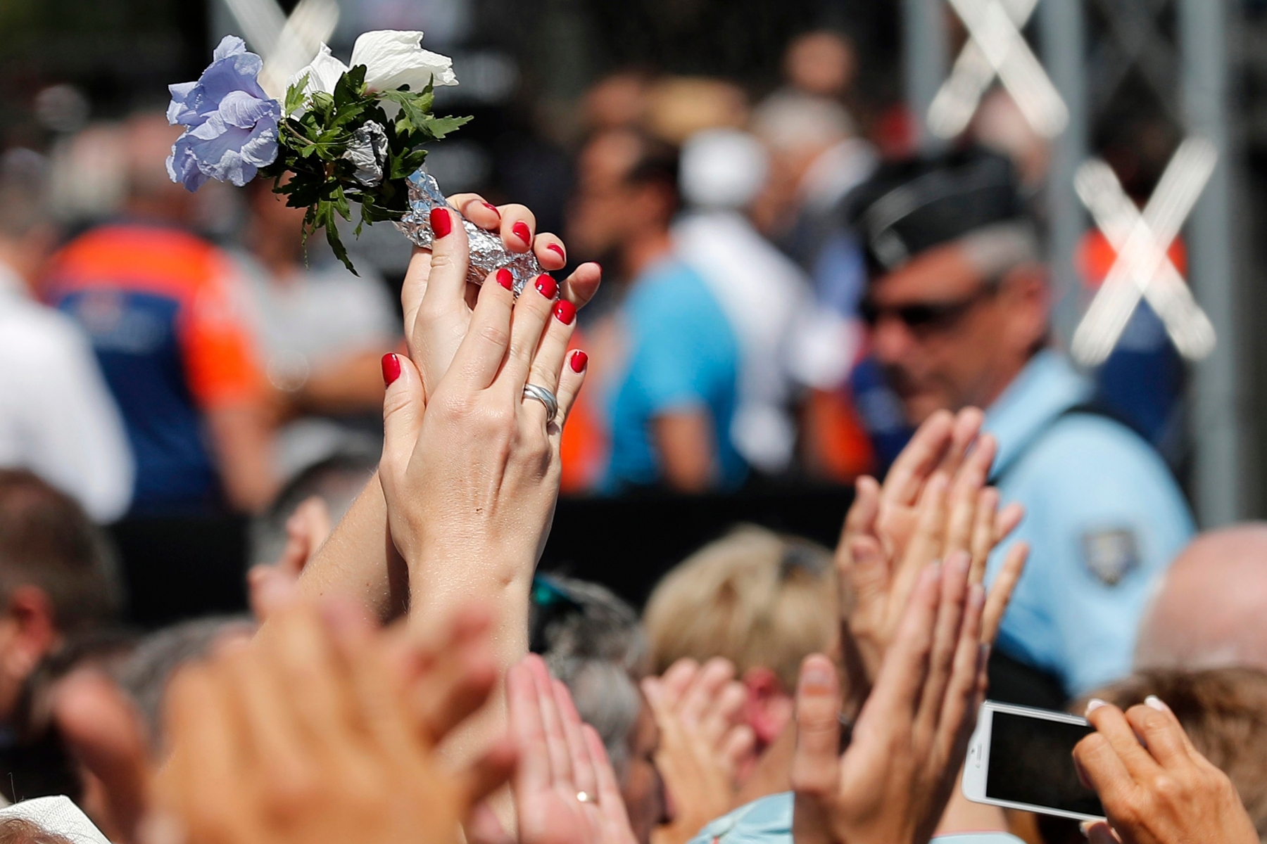 People give applause to police officers and rescue team after a minute of silence on the famed Promenade des Anglais in Nice, southern France, to honor the victims of an attack near the area where a truck mowed through revelers, Monday, July 18, 2016. France is holding a national moment of silence for 84 people killed by a truck rampage in Nice, and thousands of people are massed on the waterfront promenade where Bastille Day celebrations became a killing field.(AP Photo/Francois Mori) France Truck Attack