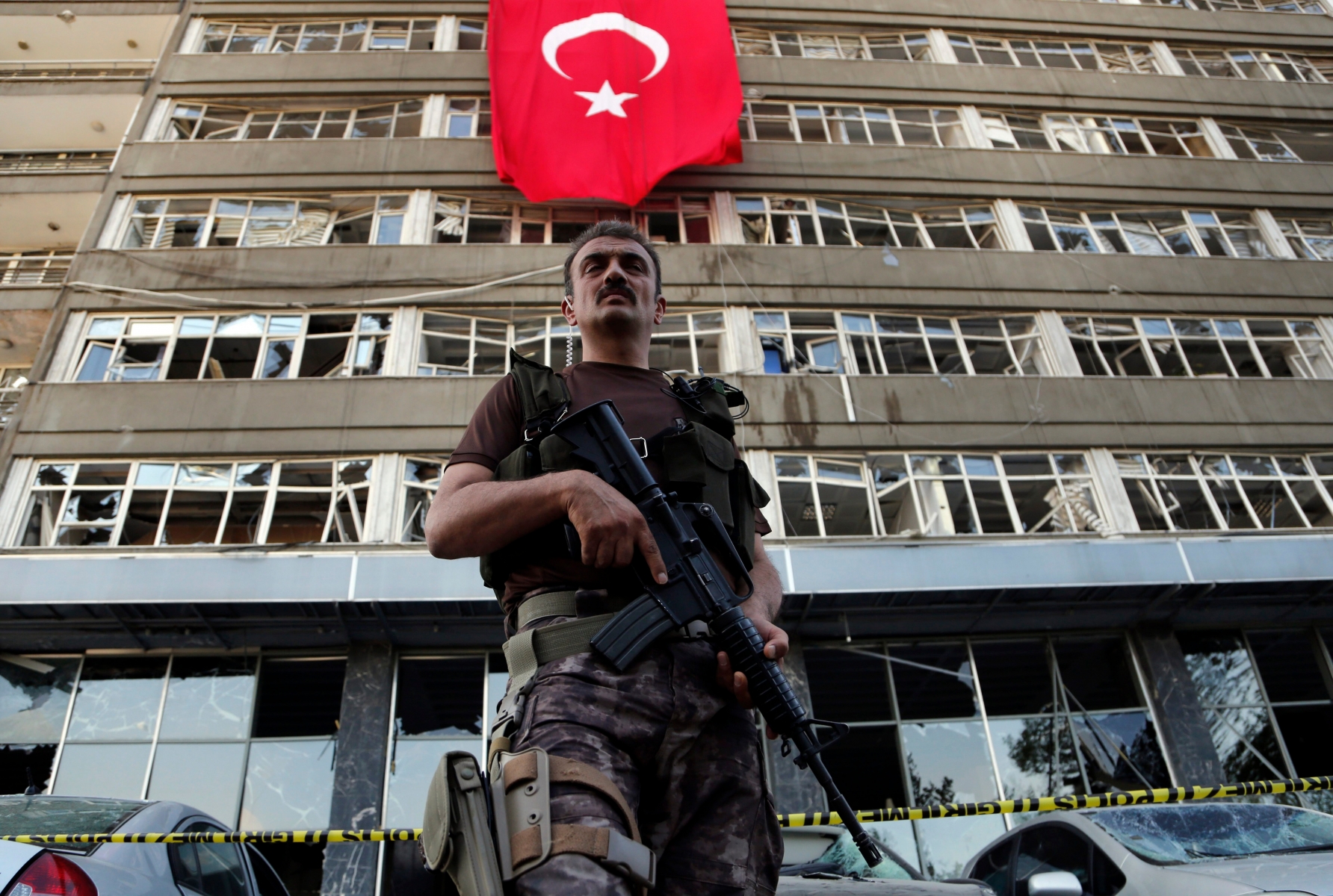 A Turkish special forces policeman stands guard in front of a damaged building inside the special forces policemen base which was attacked by the Turkish warplanes during the failed military coup last Friday, in Ankara, Turkey, Tuesday, July 19, 2016. The violence surrounding the Friday night coup attempt claimed the lives of 208 government supporters and 24 coup plotters, according to the government. Turkey says Fethullah Gulen, a U.S.-based Muslim cleric, was behind the coup and has demanded his extradition. Gulen has denied any knowledge of the failed coup. (AP Photo/Hussein Malla) Turkey Military Coup