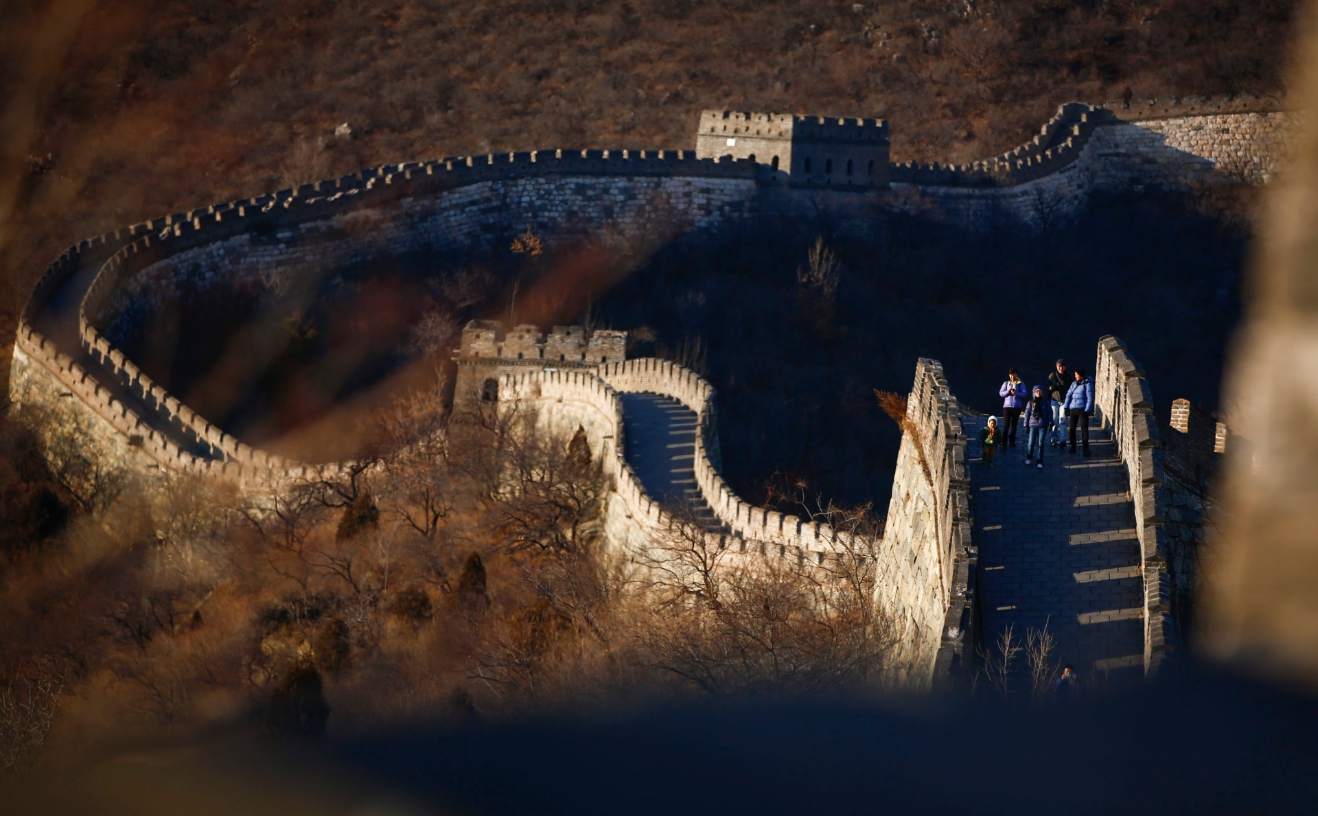 epa03995132 Tourists walk along the Great Wall at Mutianyu on the outskirts of Beijing, China, 18 December 2013. Built on mountain ridges about 70 kilometers from the center of Beijing, the Great Wall at Mutianyu, a section of one of the new seven wonders of the world, is a popular section though not as crowded as other more touristy like Badaling. With 22 watch towers and stretching 2.5 kilometers, this Ming Dinasty (1368 - 1627) Great Wall serves as a great escape from city life, especially on clear days. The Great Wall of China has been a UNESCO recognized World Heritage Site since 1987, and one of the new seven wonders of the world since 2007.  EPA/DIEGO AZUBEL CHINA GREAT WALL