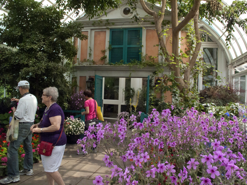 Au début de la promenade, à l'intérieur des grandes serres victoriennes du jardin de Monet dans le parc botanique de New York, le visiteur est accueilli par une reproduction de la façade de la maison de Giverny, avec les mêmes persiennes vertes qu'en Normandie (nord-ouest de la France).