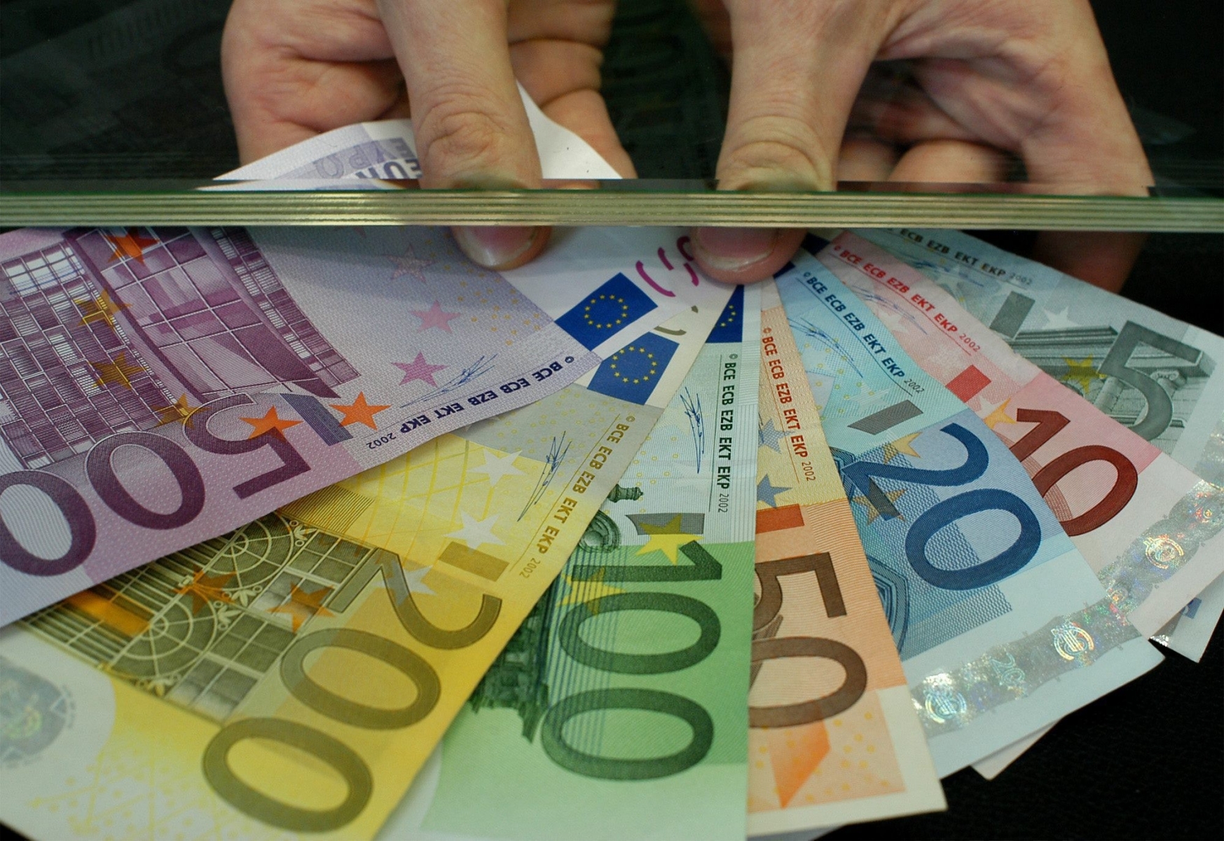 THEMENBILD --- Ein Mitarbeiter einer Geldwechselstube zeigt Euro-Scheine in Frankfurt am 23. Mai 2003. Der Traum vom faelschungssicheren Euro ist laengst ausgetraeumt. Vor vier Jahren wurden die Banknoten als vermeintlich sicheres Bargeld unters Volk gebracht, doch heute taucht immer mehr Falschgeld auf. Nun ruestet der Euro auf. Die Europaeische Zentralbank (EZB) bereitet eine neue Banknotenserie vor, die bis 2010 auf den Markt kommen soll. Diese Scheine werden neuartige Sicherheitsmerkmale besitzen, die den Faelschern das Leben schwer machen. Unter hoechster Geheimhaltungsstufe hat die EZB begonnen, neue Tricks auszutuefteln. (KEYSTONE/AP Photo/Udo Weitz) EUROPA NEUE EURO BANKNOTEN
