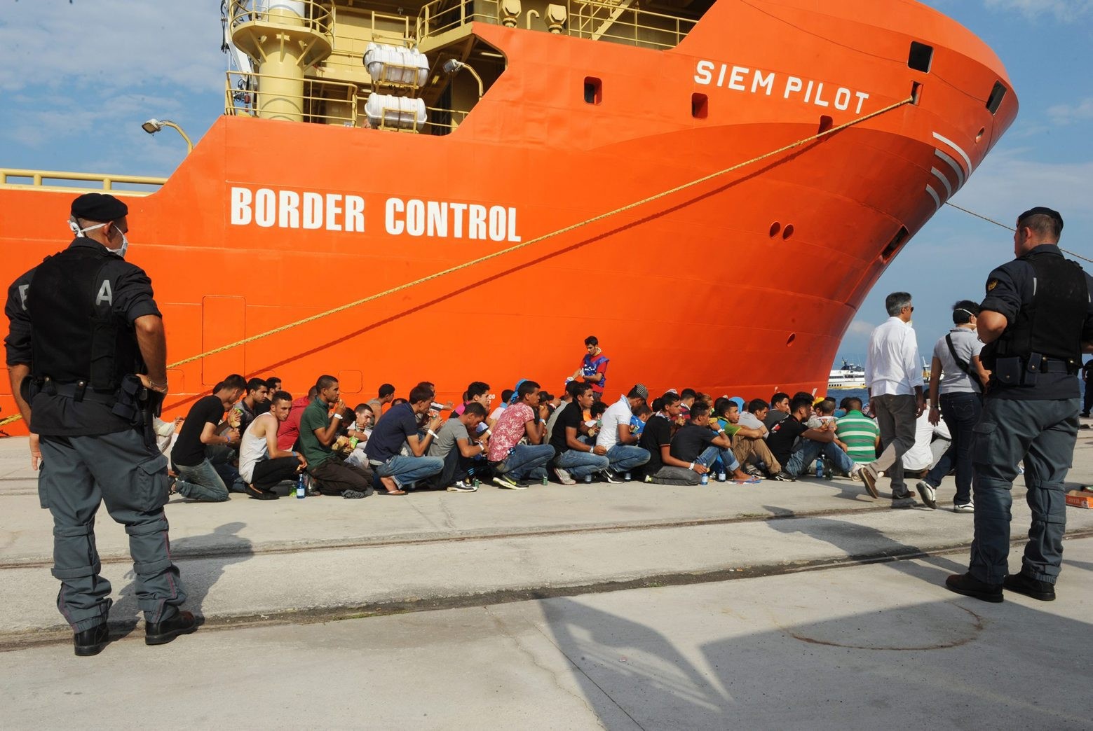 Rescued migrants line up after disembarking from the Norwegian cargo ship Siem Pilot at the Reggio Calabria's harbor, Italy, Saturday, Aug. 8, 2015. Nearly 100,000 migrants have reached Italy by sea this year, and 90,000 reached Greece by sea, the IOM said. (AP Photo/Adriana Sapone) Italy Migrants
