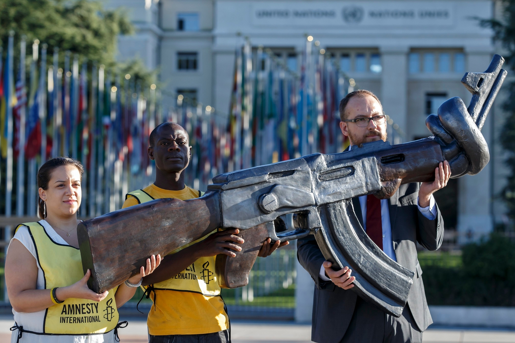 Amnesty International activists hold a giant gun replica AK-47 during a rally for calling the governments finalize a global Arms Trade Treaty (ATT) at the second Conference of the States Parties to the Arms Trade Treaty (ATT), on the Place des Nations in front of the European headquarters of the United Nation in Geneva, Switzerland, Monday, August 22, 2016. (KEYSTONE/Salvatore Di Nolfi) SWITZERLAND AMNESTY DEMO ATT