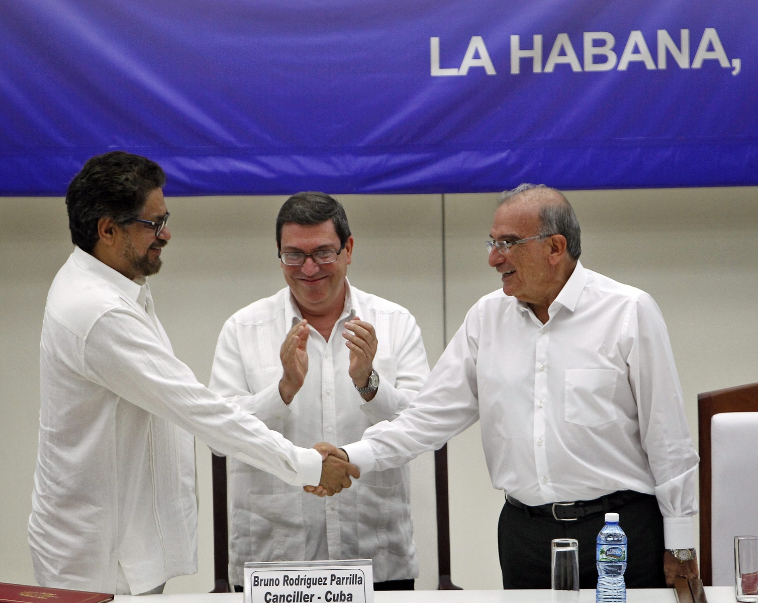 epaselect epa05509138 Second in command and leader of the delegates of the Revolutionary Armed Forces of Colombia (FARC) Luciano Marin (L), alias Ivan Marquez, shakes hands with Head of the peace delegation of the Colombian Government Humberto de la Calle (R) as Cuban Minister of Foreign Affairs Bruno Rodriguez (C) claps in Havana, Cuba, 24 August 2016. The Government of Colombia and the FARC signed the final agreement that closes the peace negotiations developed in Havana during the last four years and it must be approved by the Colombian people in a plebiscite.  EPA/ERNESTO MASTRASCUSA epaselect CUBA COLOMBIA PEACE