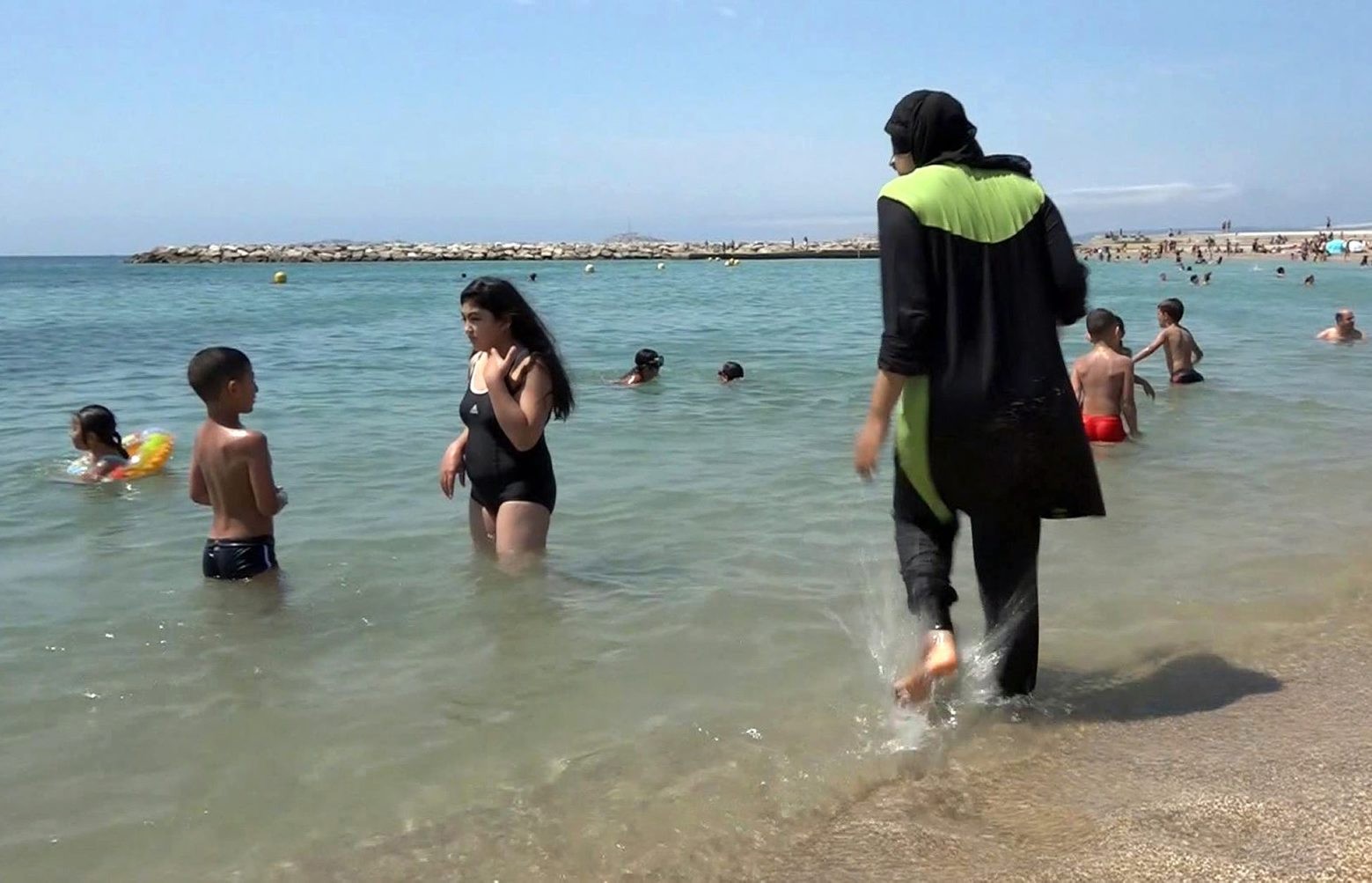 FILE - In this Aug. 4 2016 file photo made from video, Nissrine Samali, 20, gets into the sea wearing a burkini, a wetsuit-like garment that also covers the head, in Marseille, southern France. France's top administrative court has overturned Friday Aug. 26, 2016 a town burkini ban amid shock and anger worldwide after some Muslim women were ordered to remove body-concealing garments on French Riviera beaches. (AP Photo, File) France Burkinis