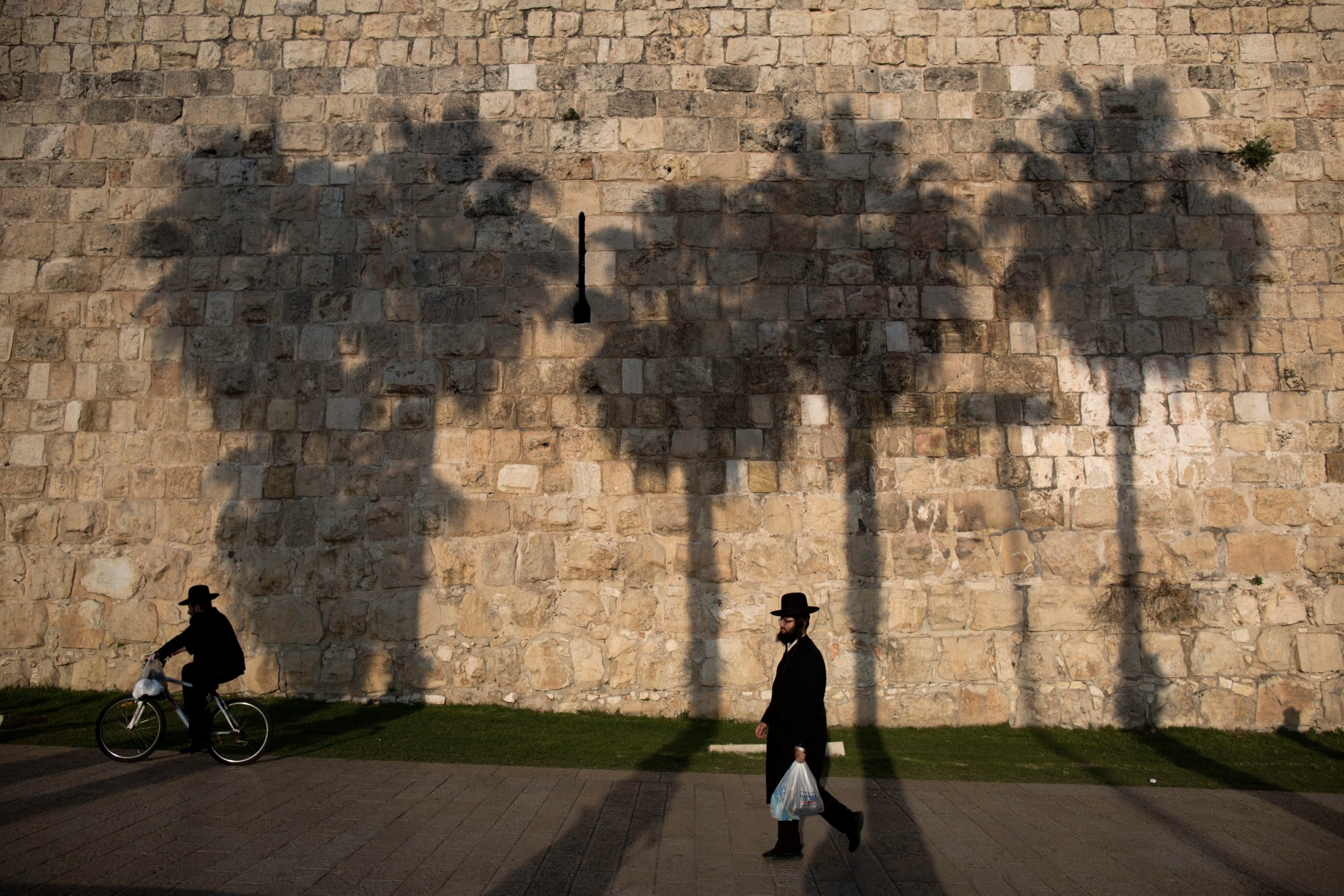 epa04542273 An Ultra-Orthodox Jewish walks along the wall of the Old City of Jerusalem, Israel, 29 December 2014.  EPA/ABIR SULTAN MIDEAST JERUSALEM OLD CITY