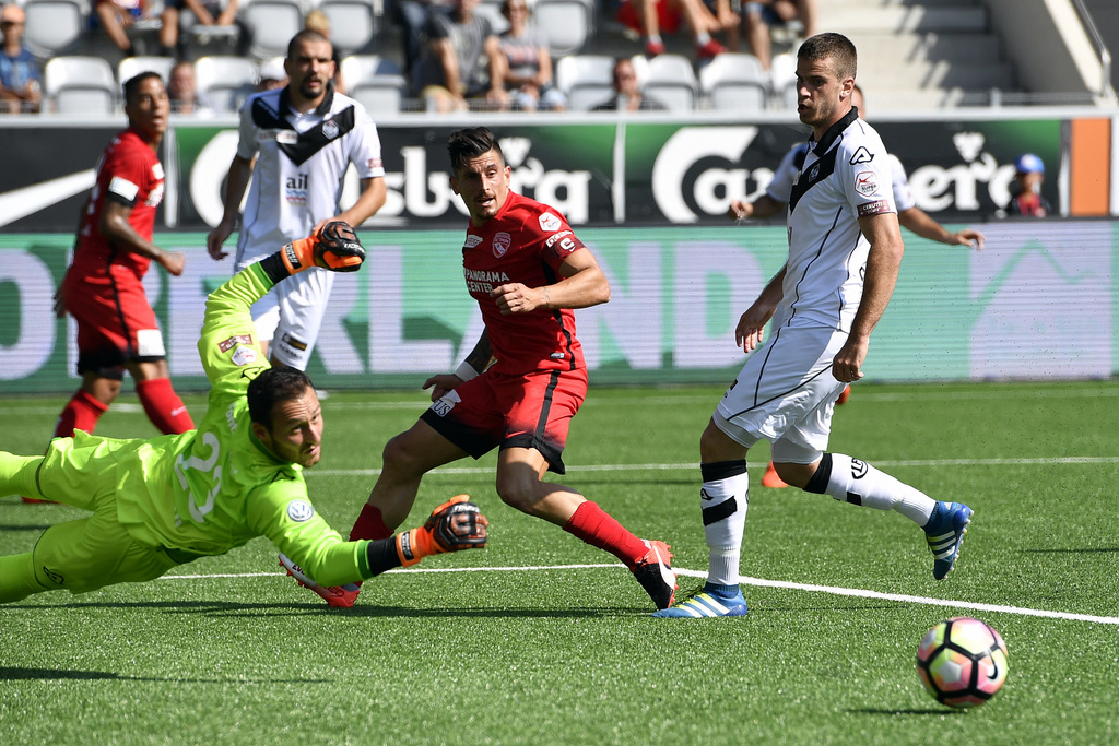 Le joueur de Thoune Dennis Hediger, au centre, face au gardien de Lugano Torhueter Mirko Salvi. Le score final sera à 2 partout.