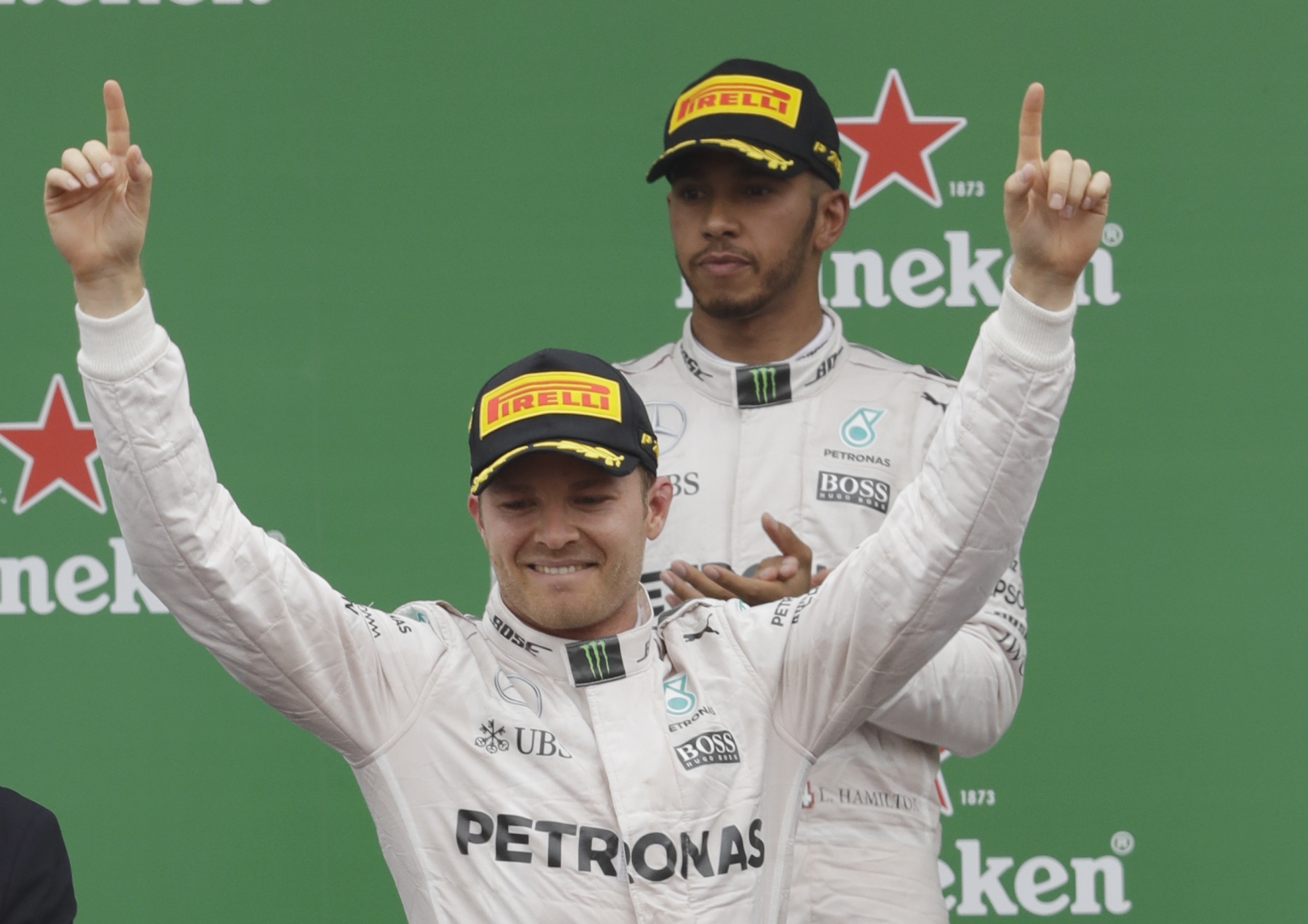 Mercedes driver Nico Rosberg of Germany, left, celebrates as second placed Mercedes driver Lewis Hamilton of Britain applaudes on the podium the Italian Formula One Grand Prix at the Monza racetrack, Italy, Sunday, Sept. 4, 2016. (AP Photo/Luca Bruno) Italy F1 GP Auto Racing