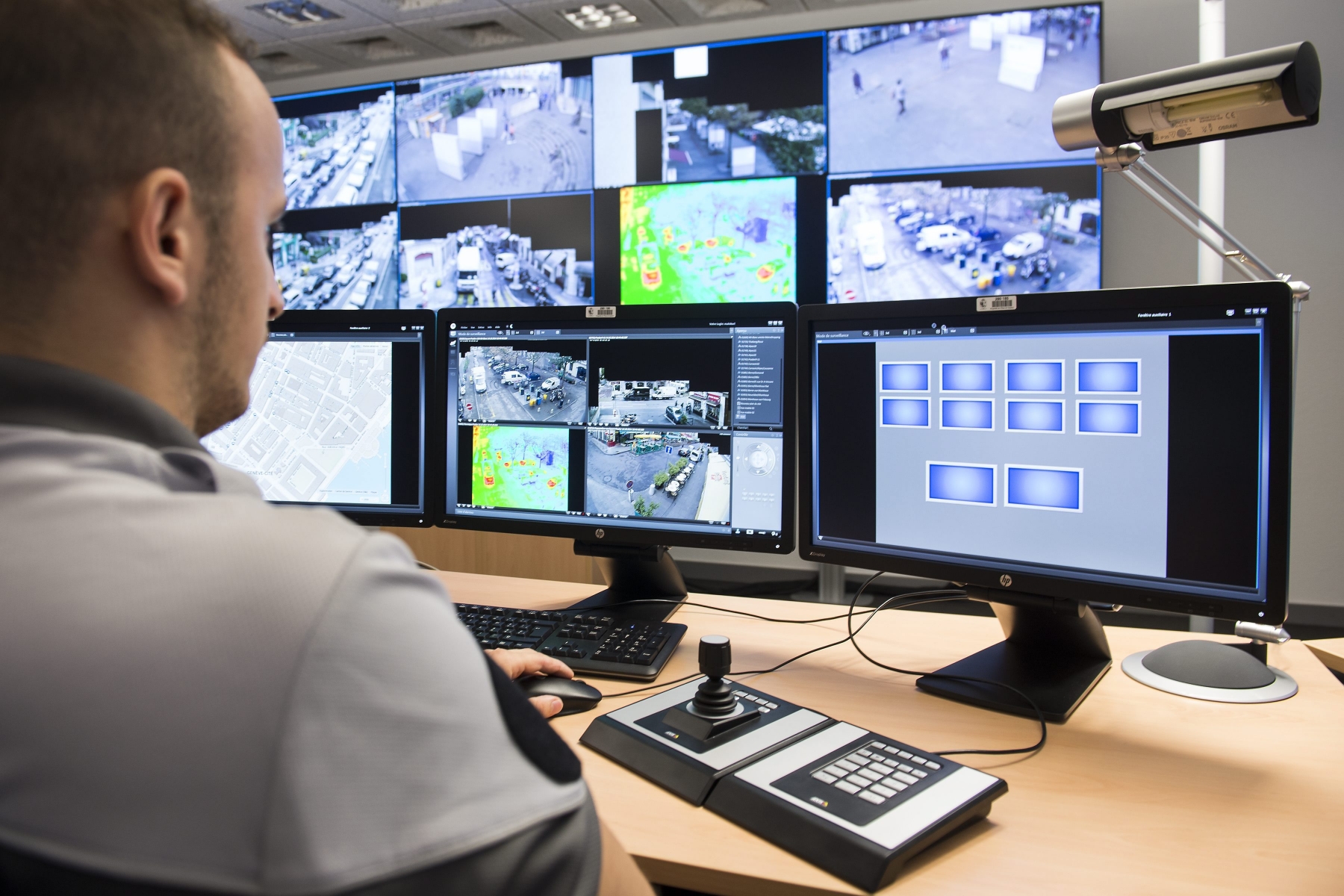 ZUR EIDGENOESSISCHEN ABSTIMMUNG UEBER DEN NACHRICHTENDIENST (NACHRICHTENDIENSTGESETZ) VOM SONNTAG, 25. SEPTEMBER 2016, STELLEN WIR IHNEN FOLGENDES BILDMATERIAL ZUR VERFUEGUNG - Un policier regarde les ecrans de la centrale de videopretection au Nouvel Hotel de police ce mardi 14 octobre 2014 a Geneve. Ce projet pilote comprenant 29 cameras de surveillance installees dans le quartier des Paquis, s'inscrit dans le cadre de la mise en euvre de la convention de lutte contre la criminalite, adoptee conjointement par le Ministere public et le Conseil d'Etat du canton de Geneve. (KEYSTONE/Jean-Christophe Bott)