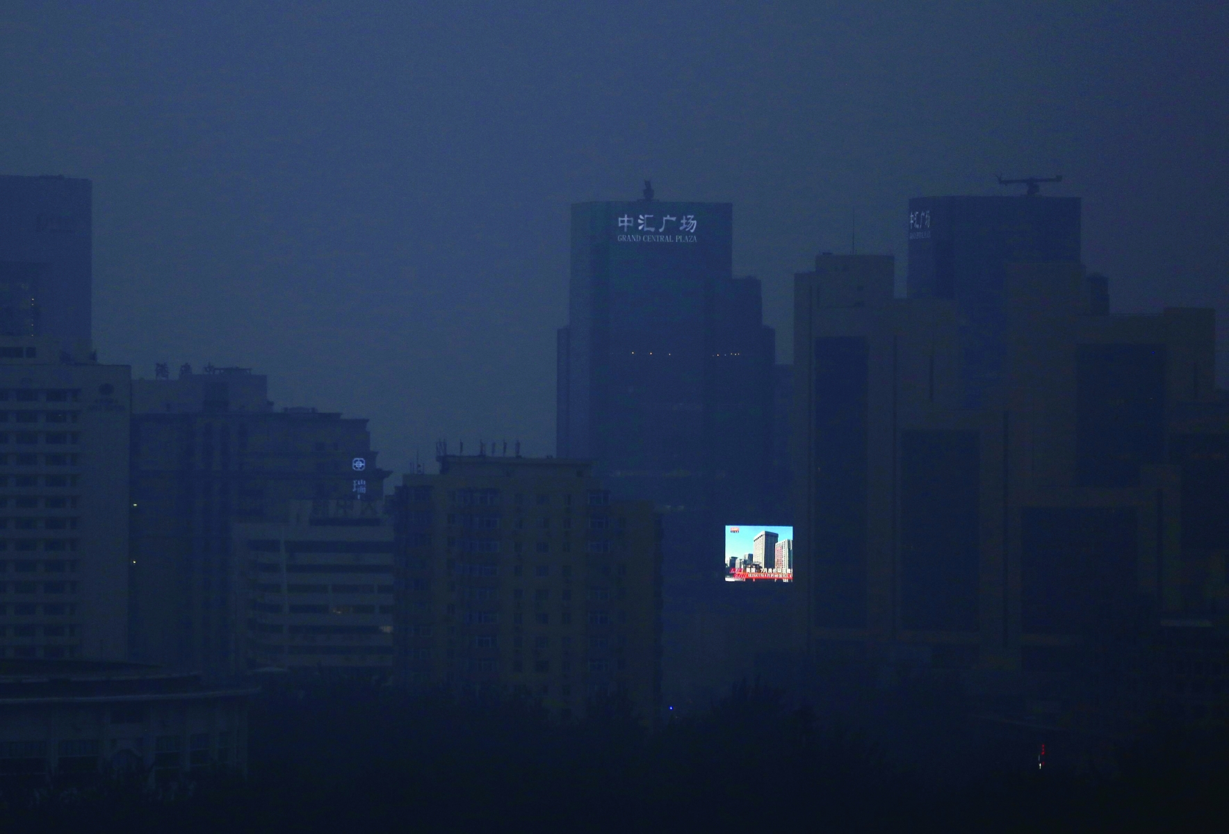 epa04416427 A large LCD screen showing a view of blue skies and buildings is seen amidst the smog clad city of Beijing, China, 25 September 2014. Vows to tackle climate change, commitments to meet emission reduction targets and promises of financial assistance were thick on the ground on 23 September when world leaders were meeting for the UN Climate Summit. China's Vice  Premier Zhang Gaoli pledged that China will provide financial help to developing countries to tackle climate change and will give 6 million dollars to a fund set up by Ban to assist developing nations.  EPA/HOW HWEE YOUNG CHINA ENVIRONMENT