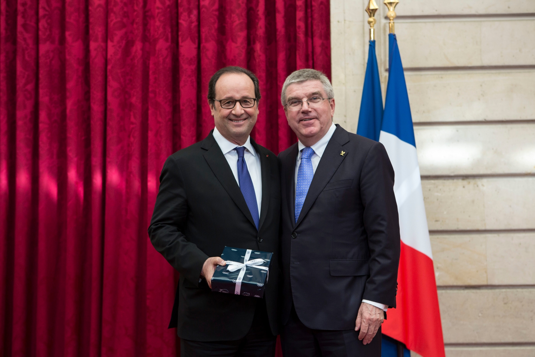 French President Francois Hollande, left, receives a gift from International Olympic Committee President Thomas Bach during a meeting at the Elysee Palace in Paris, Sunday, Oct. 2, 2016. Paris, which last hosted the Olympics in 1924, is competing against Budapest, Rome and Los Angeles for the games. (AP Photo/Kamil Zihnioglu, Pool) France Paris 2024