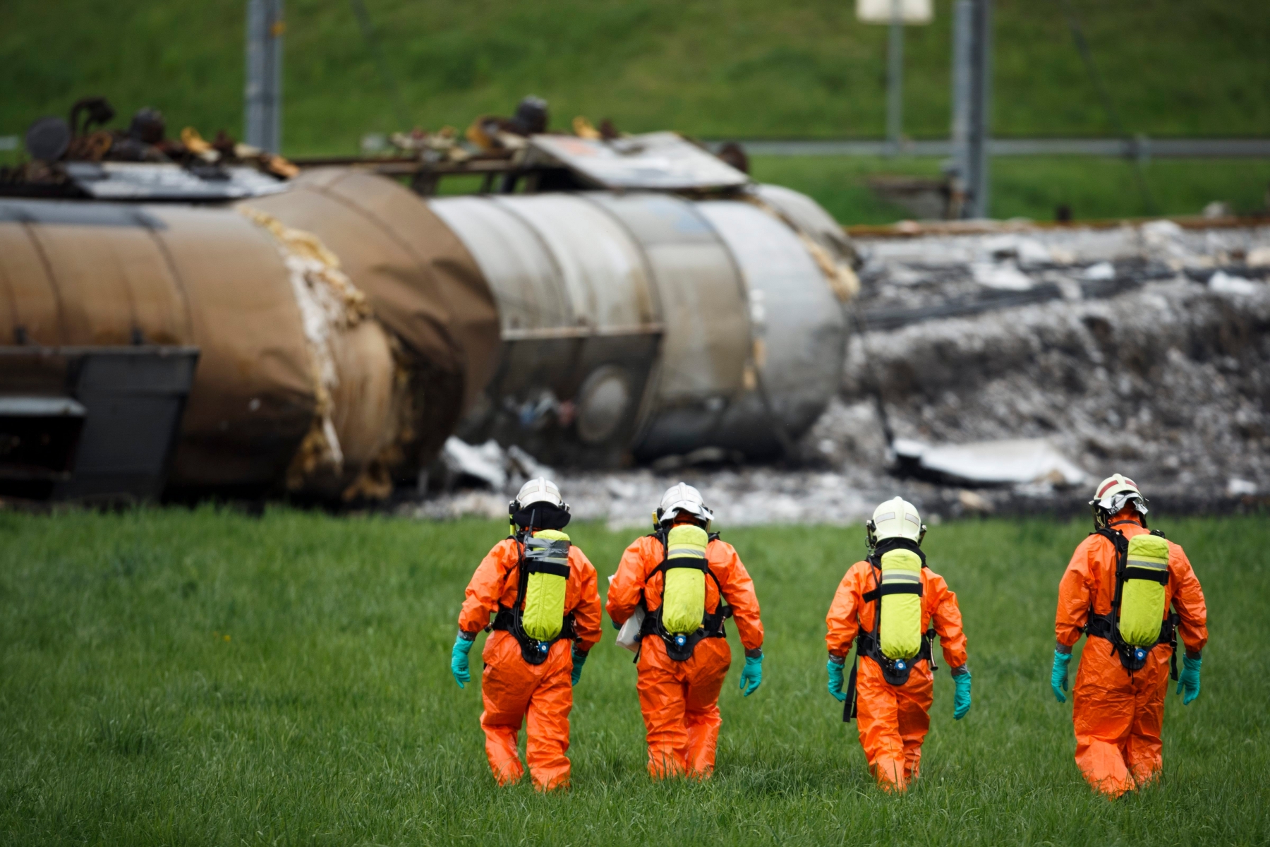 Des personnes en combinaison de protection chimique intervienent pres de wagons citerne couches suite au deraillement d'un convoi de marchandise CFF ce dimanche 26 avril 2015 a Daillens. Un train de marchandises a deraille samedi matin a 2h54 en gare de Daillens. Sans faire de blesses, le deraillement du convoi transportant des marchandises dangereuses necesitera pusieurs jours pour retablir integralement le trafic feroviaire. (KEYSTONE/Valentin Flauraud) SWITZERLAND TRAIN DAILLENS