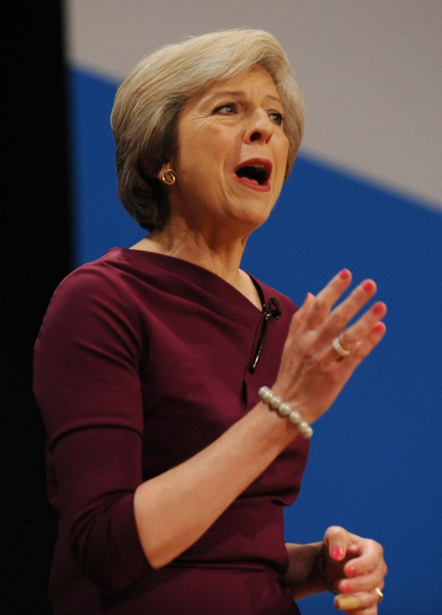Conservative Party Leader and Prime Minister, Theresa May, addresses delegates during a speech at the Conservative Party Conference at the ICC, in Birmingham, England, Wednesday, Oct. 5, 2016. May has vowed to govern from the "center ground" of politics, a day after her government alarmed liberals by saying that businesses should prioritize hiring British workers over foreign ones. (AP Photo/Rui Vieira) Britain Conservatives