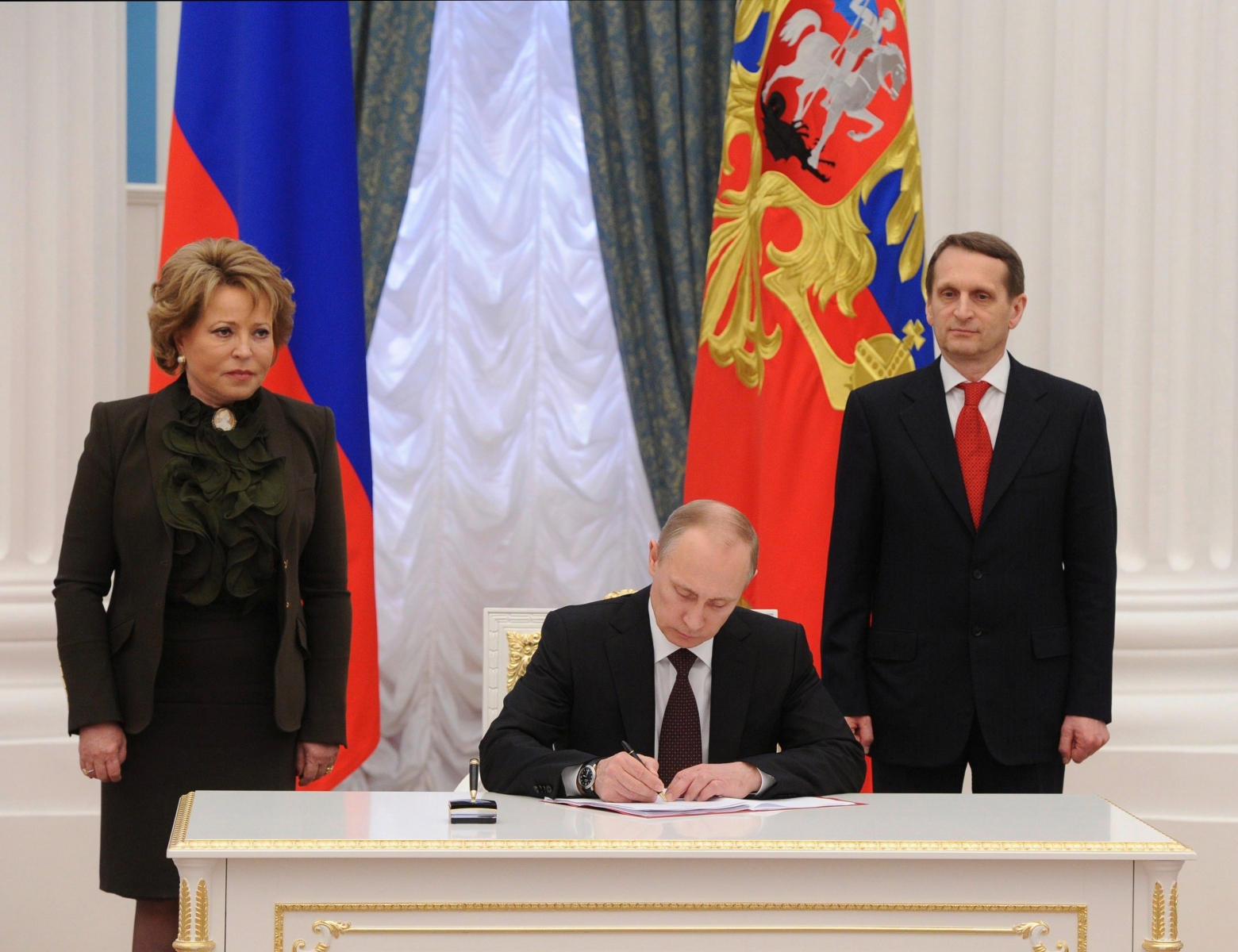 epa04134925 Russian President Vladimir Putin (C) prepares to sign a bill making Crimea and the city of Sevastopol part of Russia as Federation Council Chairman Valentina Matvienko (L) and State Duma Speaker Sergei Naryshkin (R) stand either side during a ceremony in the Kremlin's Catherine Hall in Moscow, Russia, 21 March 2014.  EPA/MIKHAIL KLIMENTYEV / RIA NOVOSTI / KREMLIN POOL MANDATORY CREDIT RUSSLAND UKRAINE KONFLIKT KRIM KRISE ABSTIMMUNG