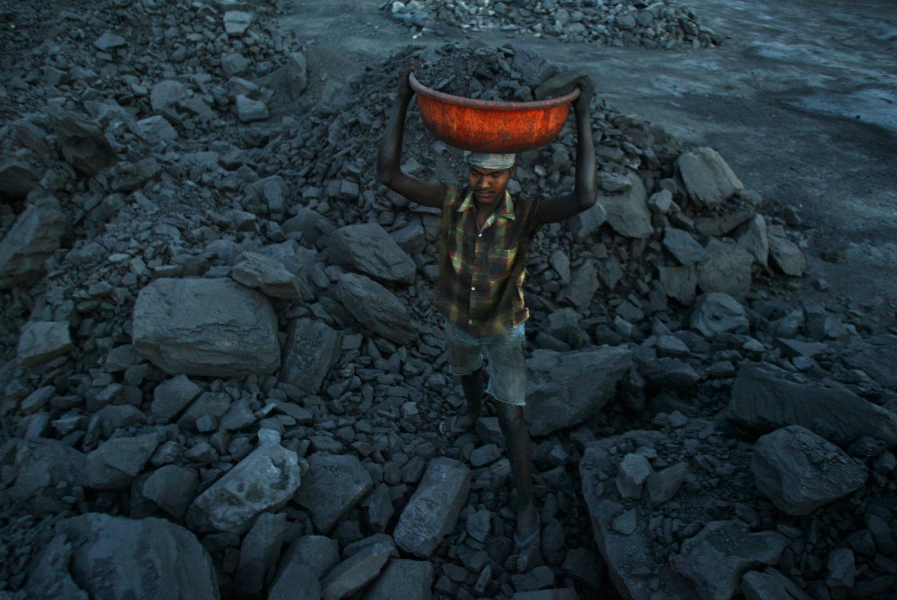 An Indian laborer carries coal as he works in a coal depot near Manguli Chhak in Cuttack district, Orissa, India, Monday, April 12, 2010. India's industrial output grew 15.1 percent in February, less than expected, after government moves to unwind stimulus measures in the face of rising inflation, official figures showed Monday. (AP Photo/Biswaranjan Rout) India Industrial Production