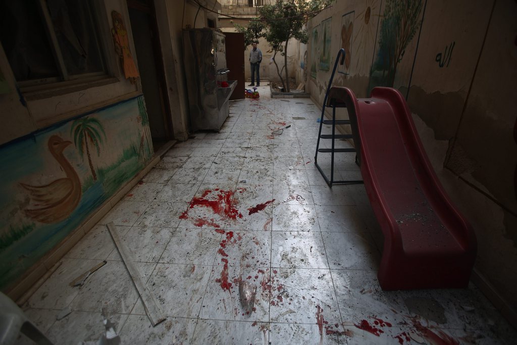 Dans la garderie, des traces de sang étaient visibles sur le sol, à côté d'un mur décoré avec des dessins d'enfants. 