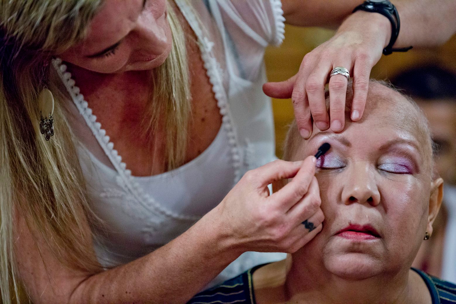 In this Nov. 6, 2013 photo, volunteer Cecilia Sanjurjo applies eye shadow to Cristina Ferreira's eyelid during a "Look Good Feel Better" workshop that offers free lessons in makeup and skin care for women dealing with the physical and psychological trauma of cancer, in Buenos Aires, Argentina. These arenít the kind of makeup tips youíd find at a shopping mall lipstick stand. Techniques include covering up extremely dark circles, creating the impression of eyelashes, and drawing-on eyebrows where none remain. Lastly, women are taught how to properly wrap headscarves, which should be made of cotton rather than silk to avoid slipping off smooth pates. (AP Photo/Natacha Pisarenko) Argentina Cancer Beauty
