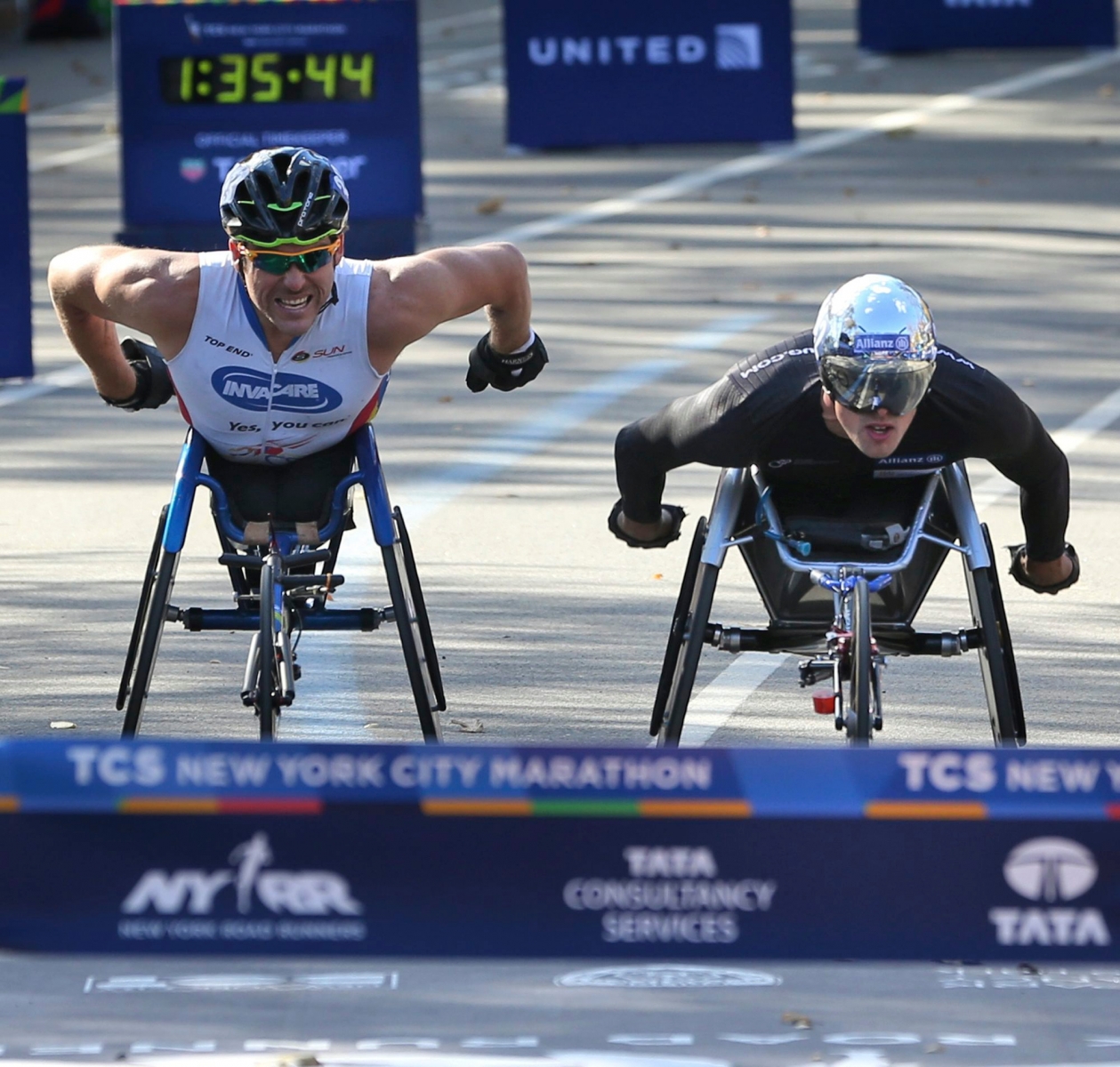 Marcel Hug of Switzerland, right, races to the finish line just ahead of Kurt Fearnley of Australia, in the men's wheelchair division of the 2016 New York City Marathon in New York, Sunday, Nov. 6, 2016. (AP Photo/Seth Wenig) NYC Marathon