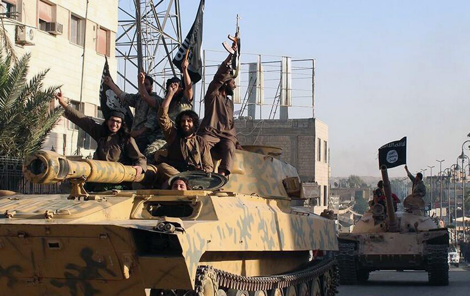 FILE - In this undated image posted by the Raqqa Media Center, in Islamic State group-held territory, on Monday, June 30, 2014, which has been verified and is consistent with other AP reporting, fighters from the al-Qaida linked Islamic State of Iraq and the Levant (ISIL) ride tanks during a parade in Raqqa, Syria. (Raqqa Media Center via AP, File) INSIDE THE CALIPHATE TIMELINE