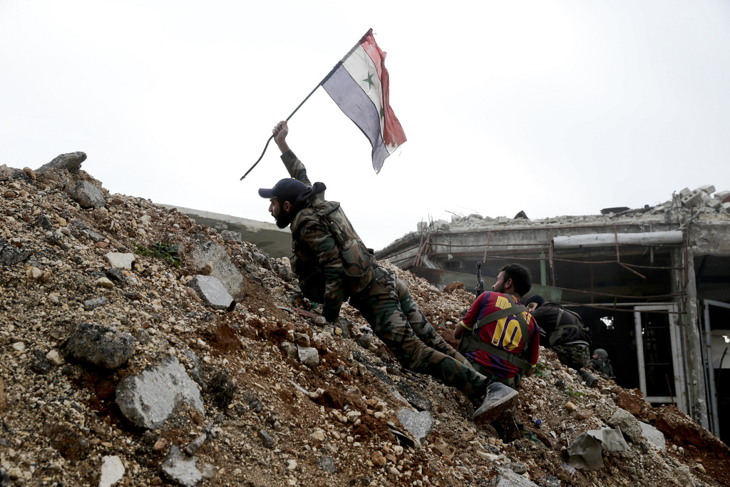 Un soldat brandit un drapeau syrien à Alep.