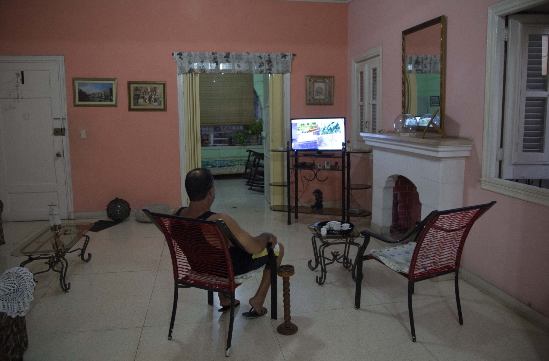 A home owner sits in his living room at his home with rooms for rent in Havana, Cuba, Wednesday, April 1, 2015. The wildly popular online home-sharing service Airbnb will allow American travelers to book lodging in Cuba starting Thursday in the most significant U.S. business expansion on the island since the declaration of detente between the two countries late last year. (AP Photo/Desmond Boylan) CUBA AIRBNB