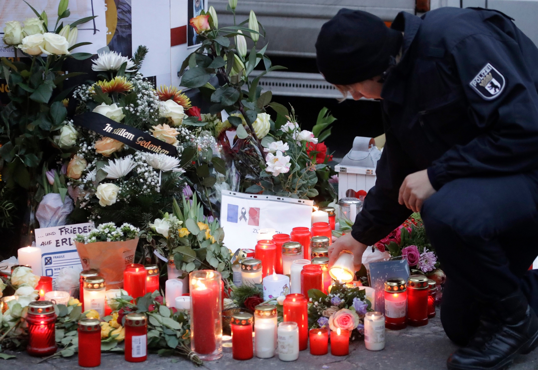A police officer lights a candle in Berlin, Germany, Tuesday, Dec. 20, 2016, the day after a truck ran into a crowded Christmas market nearby and killed several people. (AP Photo/Matthias Schrader) Germany Christmas Market