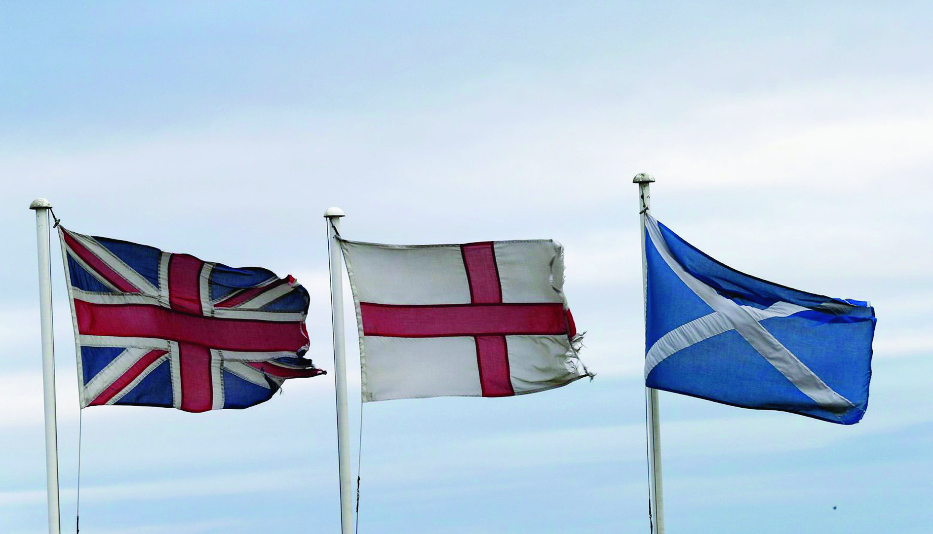 From left, the Union Jack, St George's Cross and the Saltire fly at Adderstone, England, Monday, Sept. 8, 2014. The British government plans to offer Scotland more financial autonomy in the coming days as polls predict a very close vote in the September 18 on Scottish independence. (AP Photo/Scott Heppell) Britain Scottish Referendum