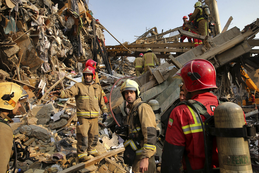 Des secouristes, des soldats et des chiens-renifleurs ont travaillé toute la nuit pour tenter de localiser la vingtaine de pompiers qui se trouvaient encore à l'intérieur du bâtiment au moment de son effondrement.