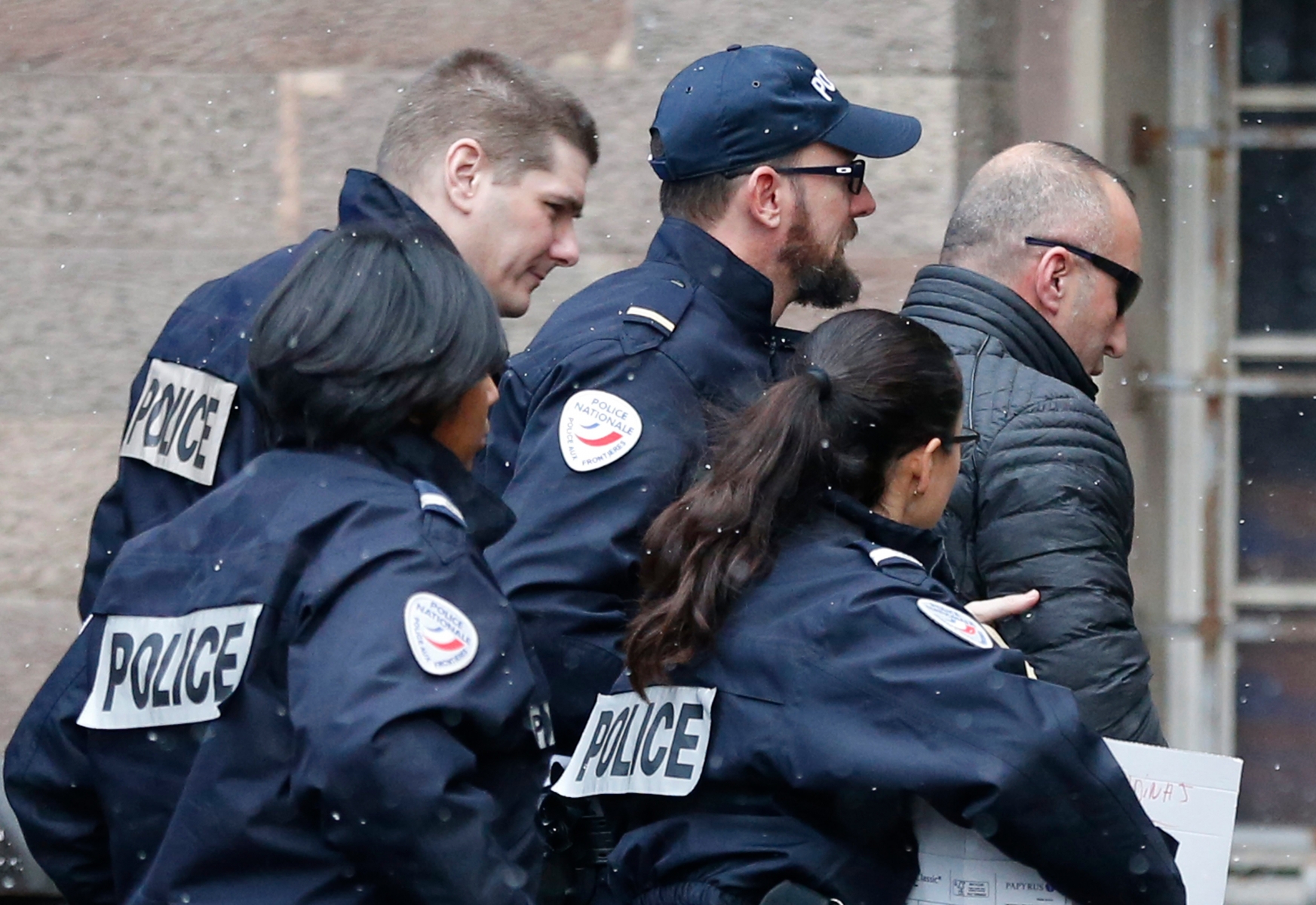 Former Kosovo prime minister Ramush Haradinaj, right, is rushed by police officers inside the Colmar courthouse, eastern France, Thursday Jan.5, 2017. Haradinaj is facing possible extradition to Serbia to face war crimes charges after being arrested at a French airport. (AP Photo/Jean-Francois Badias) France Kosovo