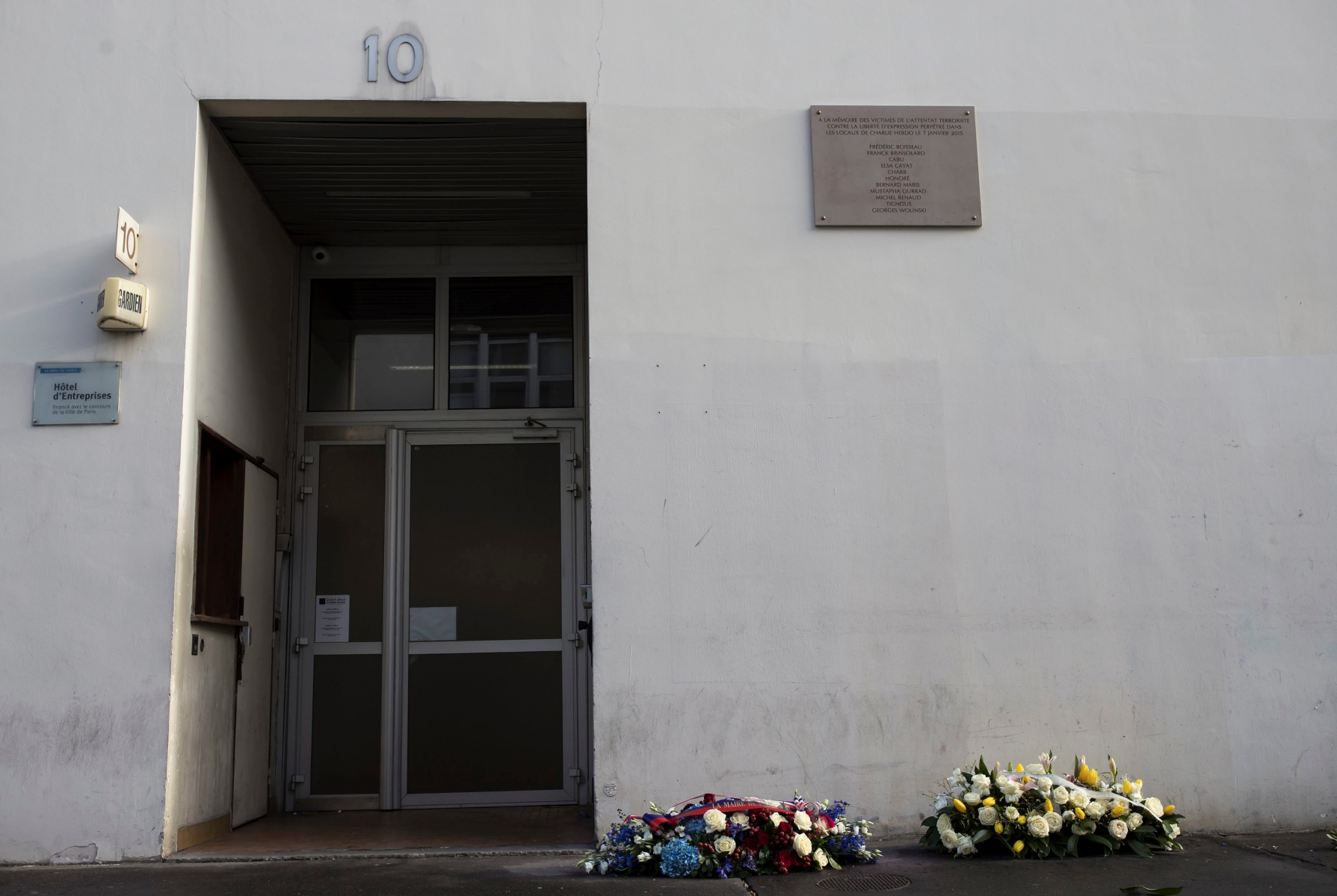 epa05699304 Wreaths sit in front of the former offices of Charlie Hebdo newspaper placed by the city of Paris to mark two-year anniversary of the Charlie Hebdo attack, in Paris, France, 05 January 2016. France this week commemorates the victims of the 07 January 2015 Islamist militant attacks on satirical weekly Charlie Hebdo and a Jewish supermarket, with the offical wreath-laying ceremonies two days ahead of the actual anniversary because it falls on the Sabbath.  EPA/IAN LANGSDON FRANCE CHARLIE HEBDO ANNIVERSARY