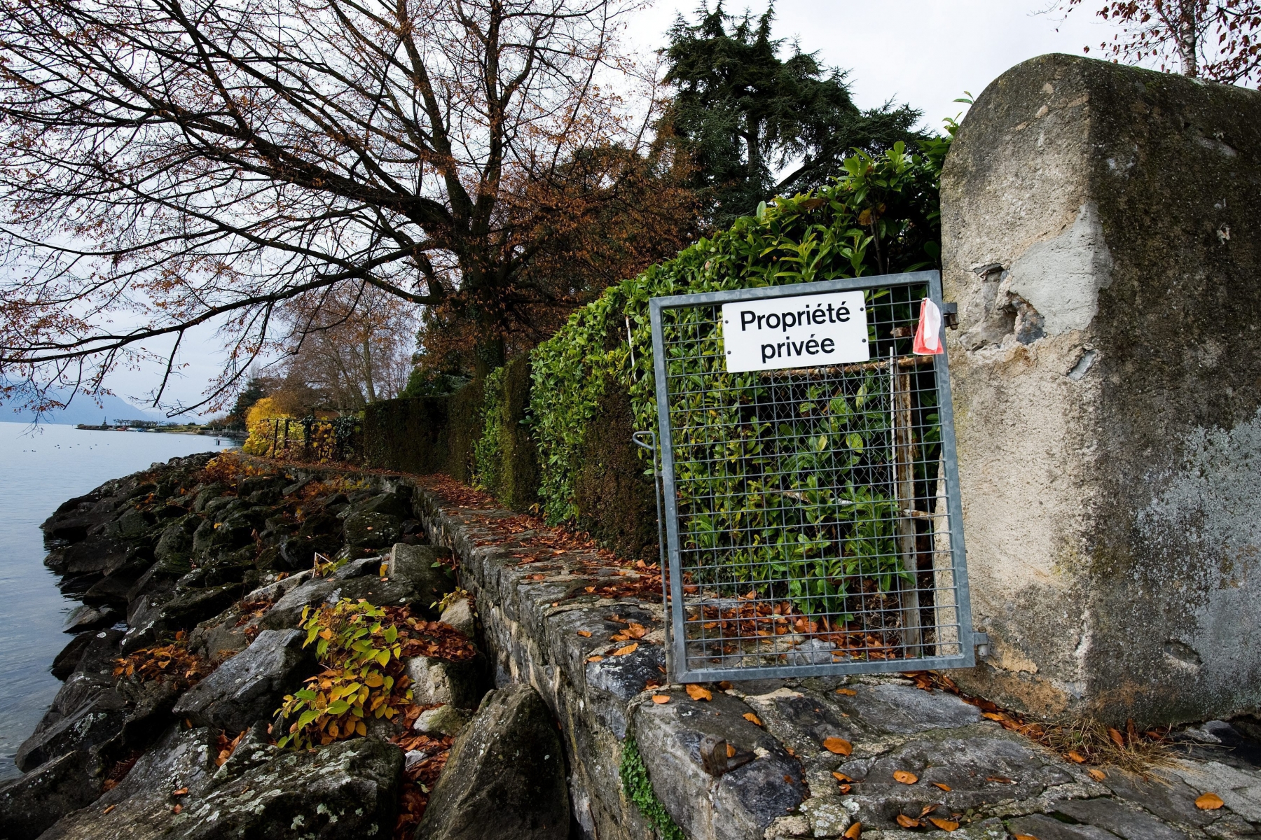 Une barriere annonce l'interdiction de passage le long du bord du Lac Leman ce mercredi 24 novembre 2010 a La Tour de Peilz. Les habitants de la Tour-de-Peilz, dans le canton de Vaud voteront le 28 novembre sur l'initiative populaire communale "pour un acces public aux rives du lac". (KEYSTONE/Jean-Christophe Bott) SUISSE VOTATION "POUR UN ACCES PUBLIC AUX RIVES DU LAC"