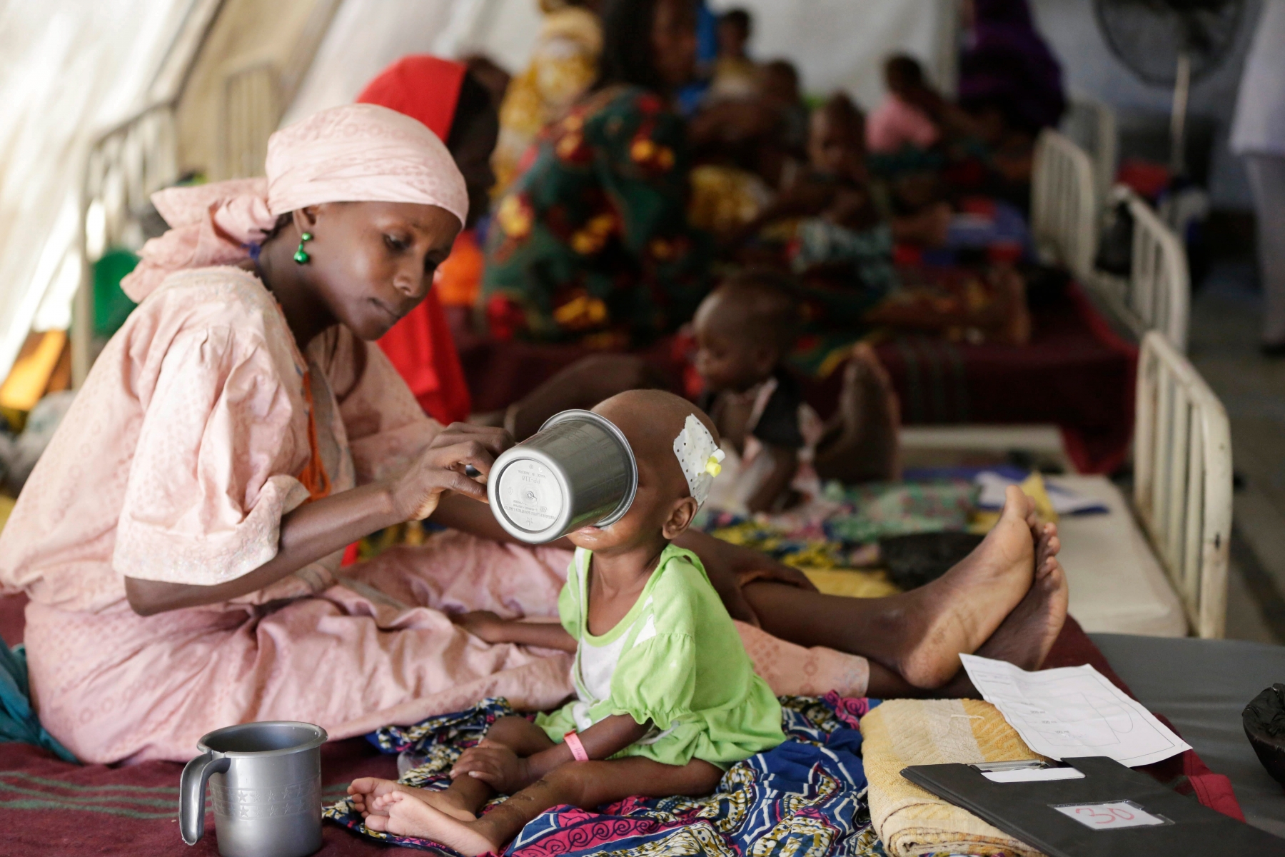 FILE - In this Monday, Aug. 29, 2016 file photo, a mother feeds her malnourished child at a feeding centre run by Doctors Without Borders in Maiduguri, Nigeria. The United Nations children's agency warned Tuesday, Feb. 21, 2017 that almost 1.4 million children are at "imminent risk of death" as famine threatens parts of South Sudan, Nigeria, Somalia and Yemen. (AP Photo/Sunday Alamba, File) Africa Famine