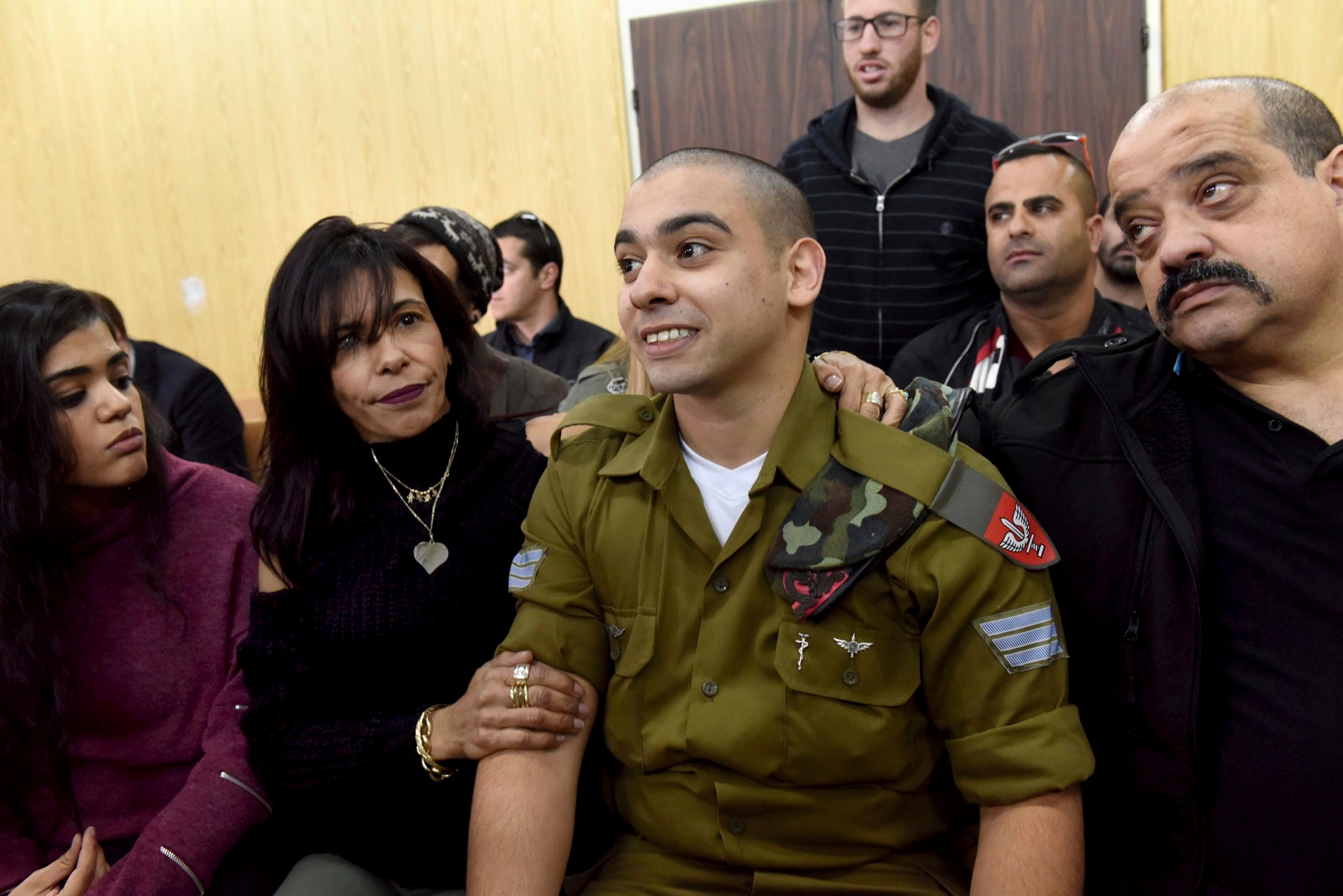 FILE -- In this January 24, 2017 file photo, Israeli soldier Sgt. Elor Azaria attends a sentencing hearing in the military court surrounded by his family, in Tel Aviv, Israel. The Israeli army said a military court on Tuesday, Feb, 21, 2017,  will sentence a soldier convicted of manslaughter for fatally shooting a wounded Palestinian assailant. Azaria faces a maximum sentence of 20 years, though analysts expect him to receive less than that. (Debbie Hill, Pool via AP, File) Israel Soldier Sentencing