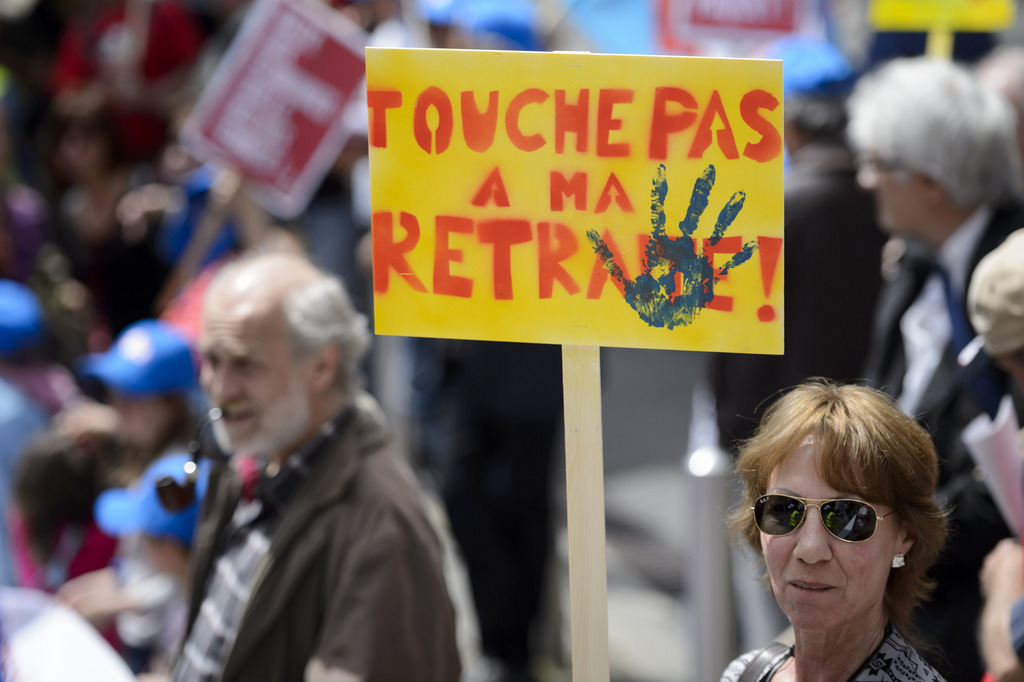Des personnes défilent avec des pancartes Non a la retraite a 65 ans lors d'une manifestation "Touche pas a ma retraite AVS".