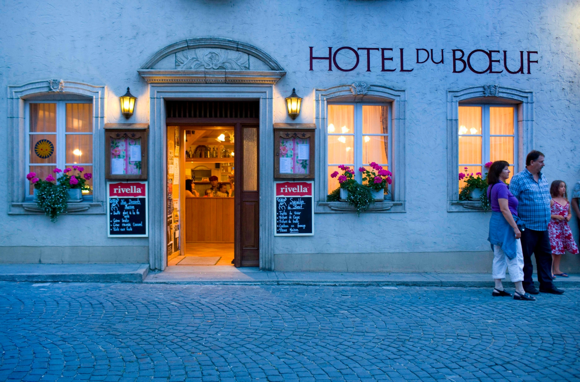 ARCHIV --- Passanten stehen vor dem Restaurant "Hotel du Boeuf" in Saint-Ursanne im Kanton Jura, aufgenommen am 31. Juli 2008. - Die Schweizer Hotellerie kann fuer 2008 das beste Tourismusjahr seit 1990 verbuchen, wie am Dienstag, 24. Februar 2009 bekannt gegeben wurde. Die Zahl der Uebernachtungen nahm gegenueber dem Vorjahr um 2,7 Prozent zu auf insgesamt 37,3 Millionen. (KEYSTONE/ Martin Ruetschi) SCHWEIZ TOURISMUS