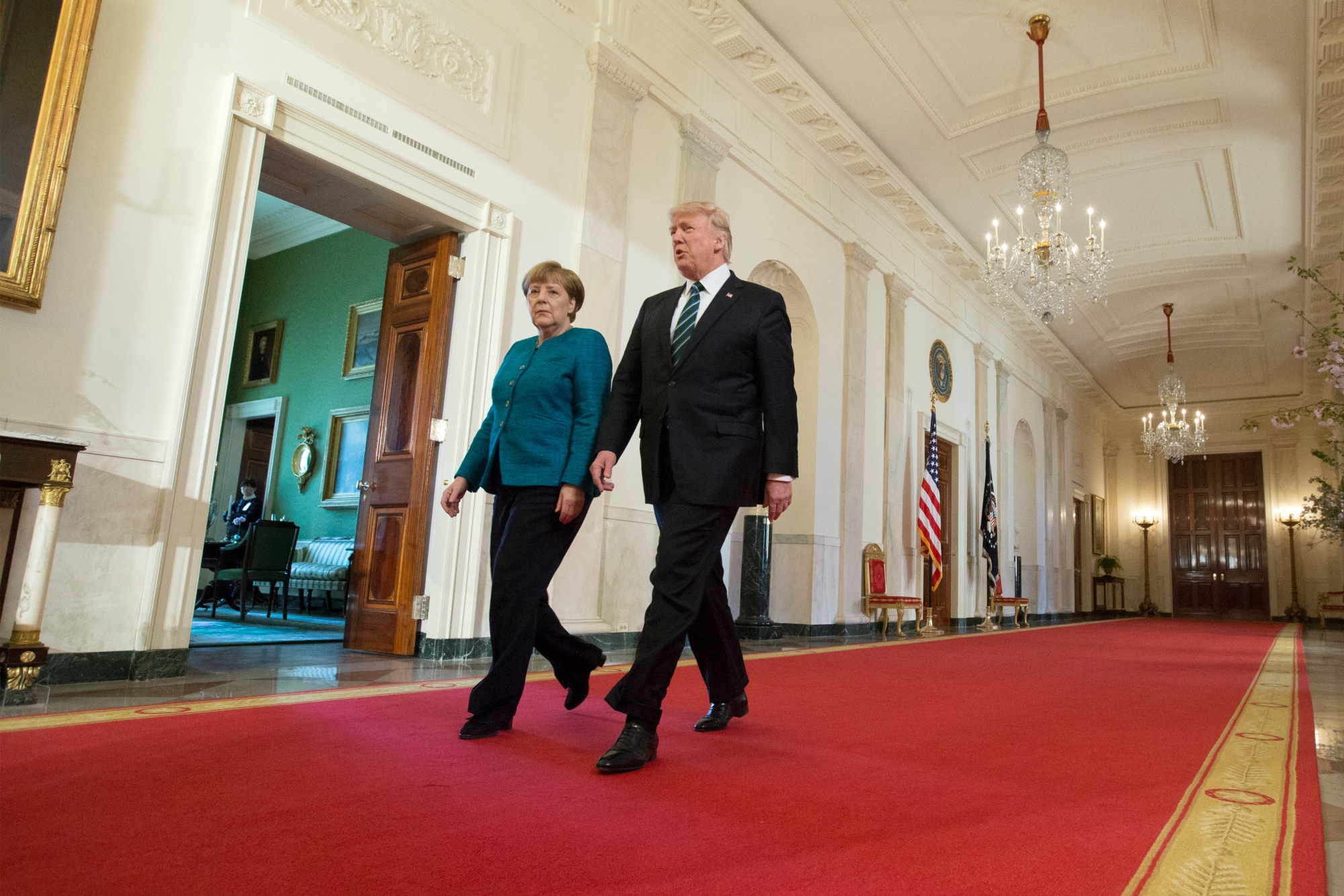 epa05854903 US President Donald J. Trump (R) and Chancellor of Germany Angela Merkel (L) walk down the Cross Hall to enter the East Room for a joint press conference in the East Room of the White House in Washington, DC, USA, 17 March 2017. Merkel and Trump meet at the White House for their first face-to-face meeting with an agenda of discussing transatlantic trade and security issues among two of the world's leading economies.  EPA/MICHAEL REYNOLDS USA GERMANY TRUMP MERKEL