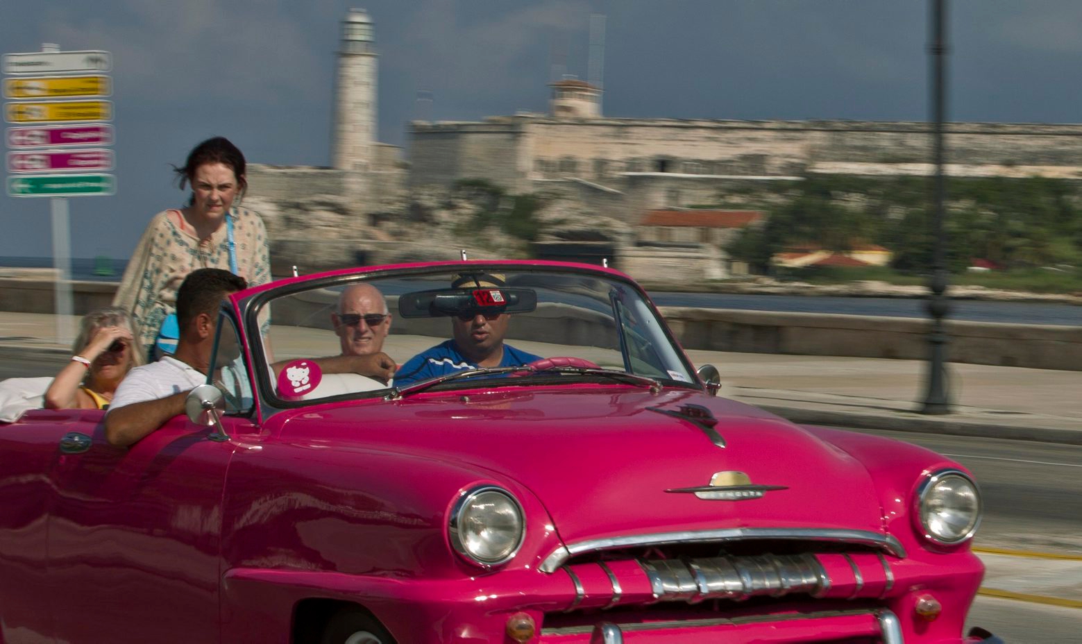In this Oct. 15, 2014 photo, tourists ride in a classic American car on the Malecon in Havana, Cuba. Those lucky enough to have a pre-revolutionary car can earn money legally by ferrying tourists _ or Cubans celebrating weddings _ along Havanaís waterfront Malecon boulevard. (AP Photo/Franklin Reyes) Cuba Classic Cars