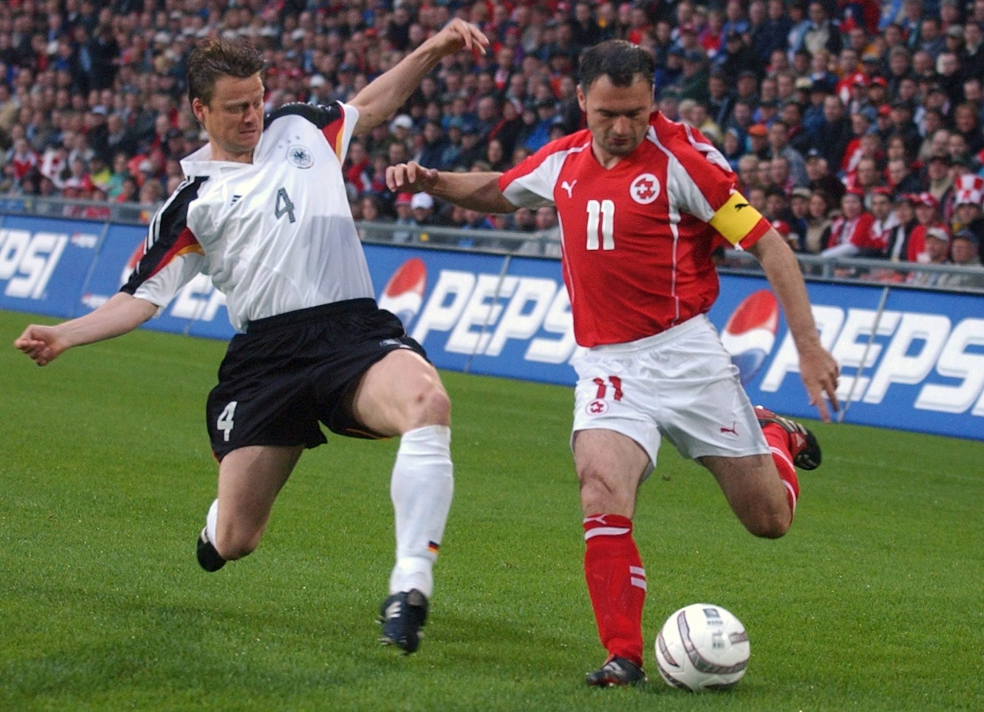 Swiss Stephane Chapuisat, right, tries to shoot against German Christian Woerns in a pre Euro2004 friendly soccer match between Switzerland and Germany, in Basel, Switzerland, Wednesday, June 2, 2004. Chapuisat plays his 100th game with the Swiss team. (KEYSTONE/Walter Bieri) FUSSBALL SCHWEIZ DEUTSCHLAND